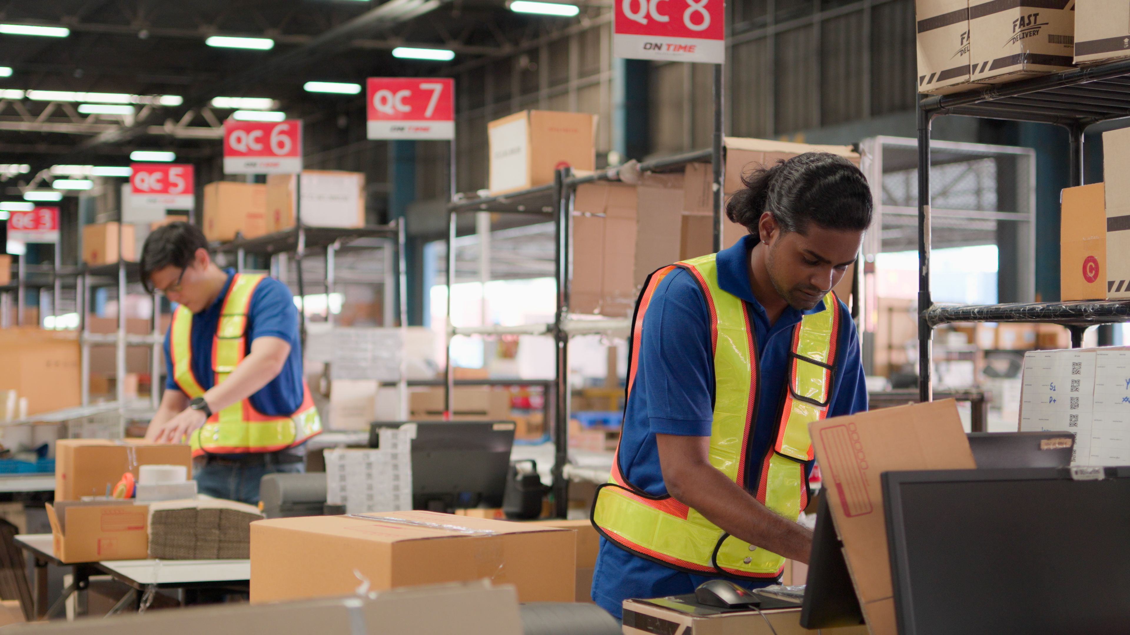 Two asian warehouse worker working checking package products in warehouse, logistic. While staff used laser barcode scanner on cardboard box, distribution center, placement in storage for shipping.