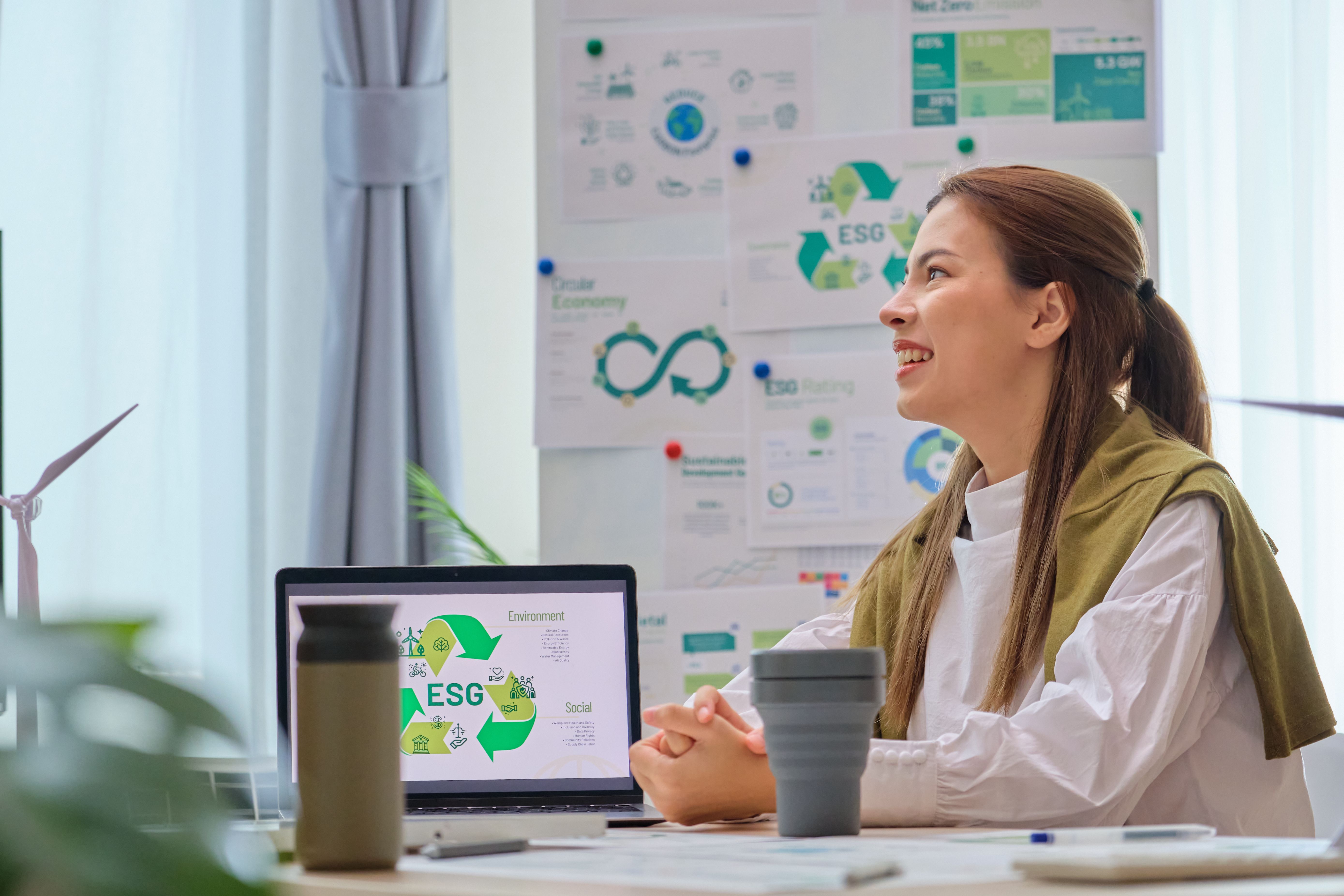 Empresaria que tiene un entorno de reunión ESG con el equipo, la sociedad y la gobernanza, discutiendo energía renovable con turbina eólica y panel solar en la oficina