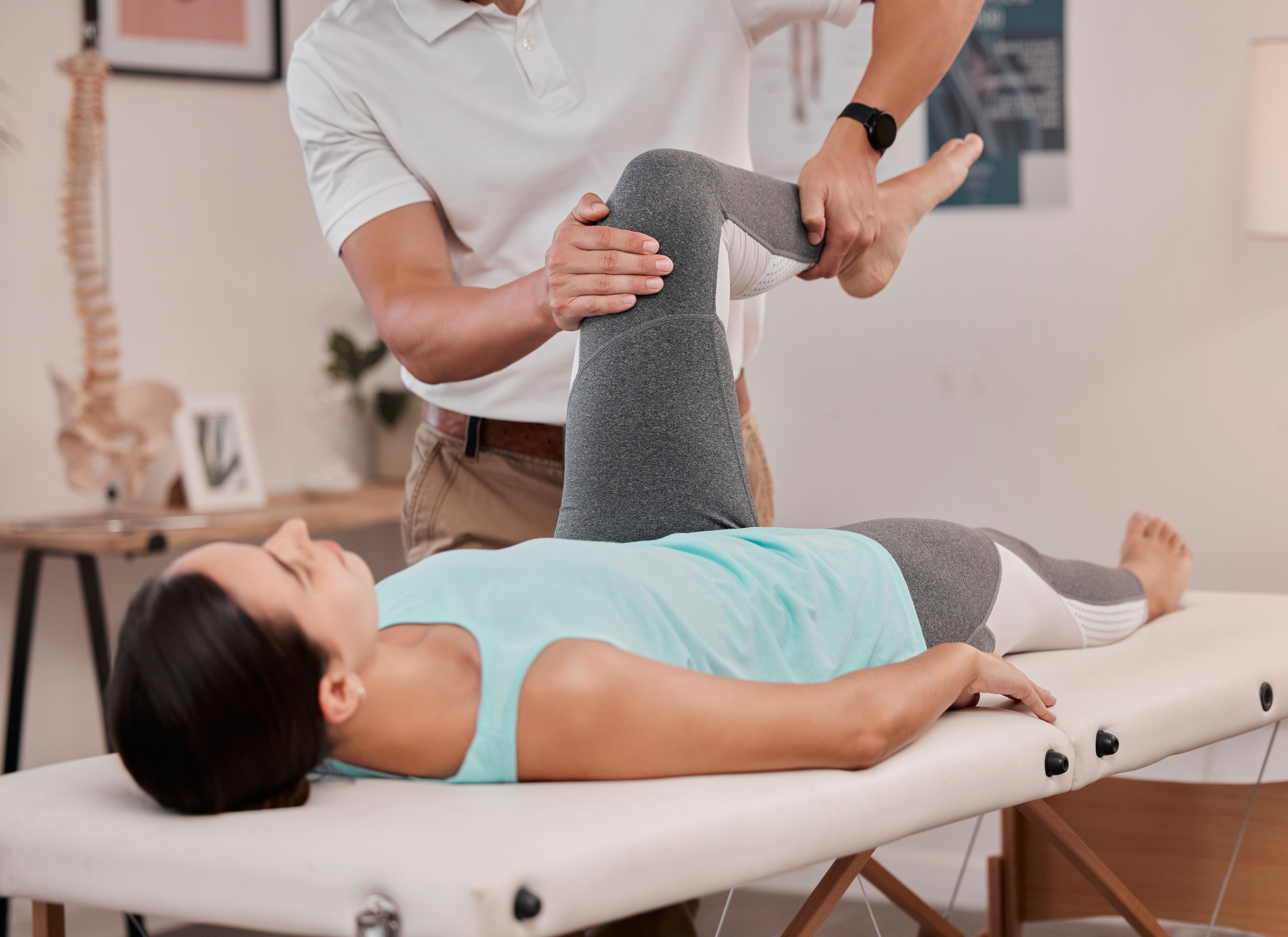 Leg, physiotherapy and healthcare of woman at hospital for rehabilitation, recovery or wellness. Help, physical therapy or female patient with chiropractor for stretching, knee pain or injury healing Leg, physiotherapy and healthcare of woman at hospital for rehabilitation, recovery or wellness. Help, physical therapy or female patient with chiropractor for stretching, knee pain or injury healing