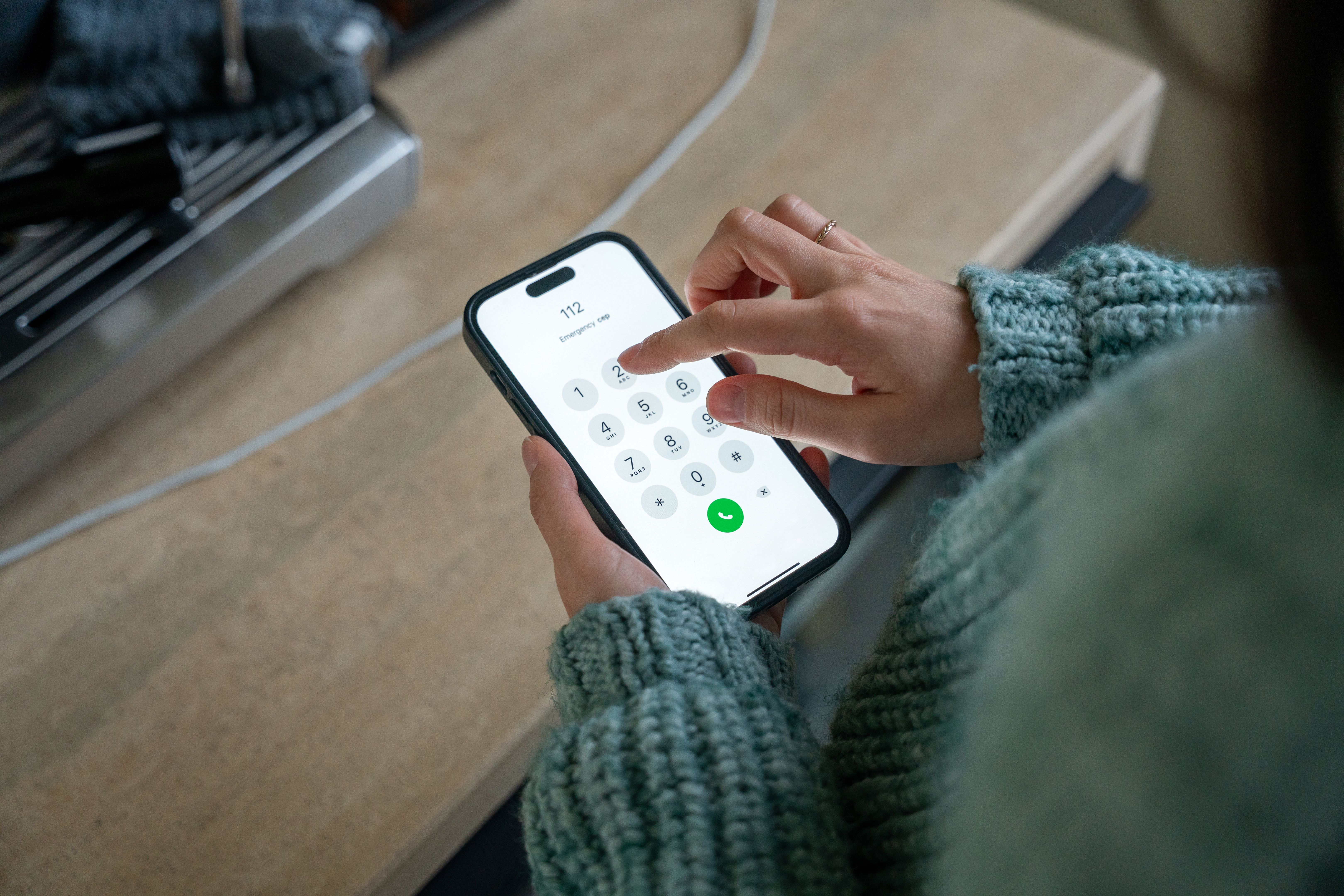 Woman dialing emergency number 112 on smartphone