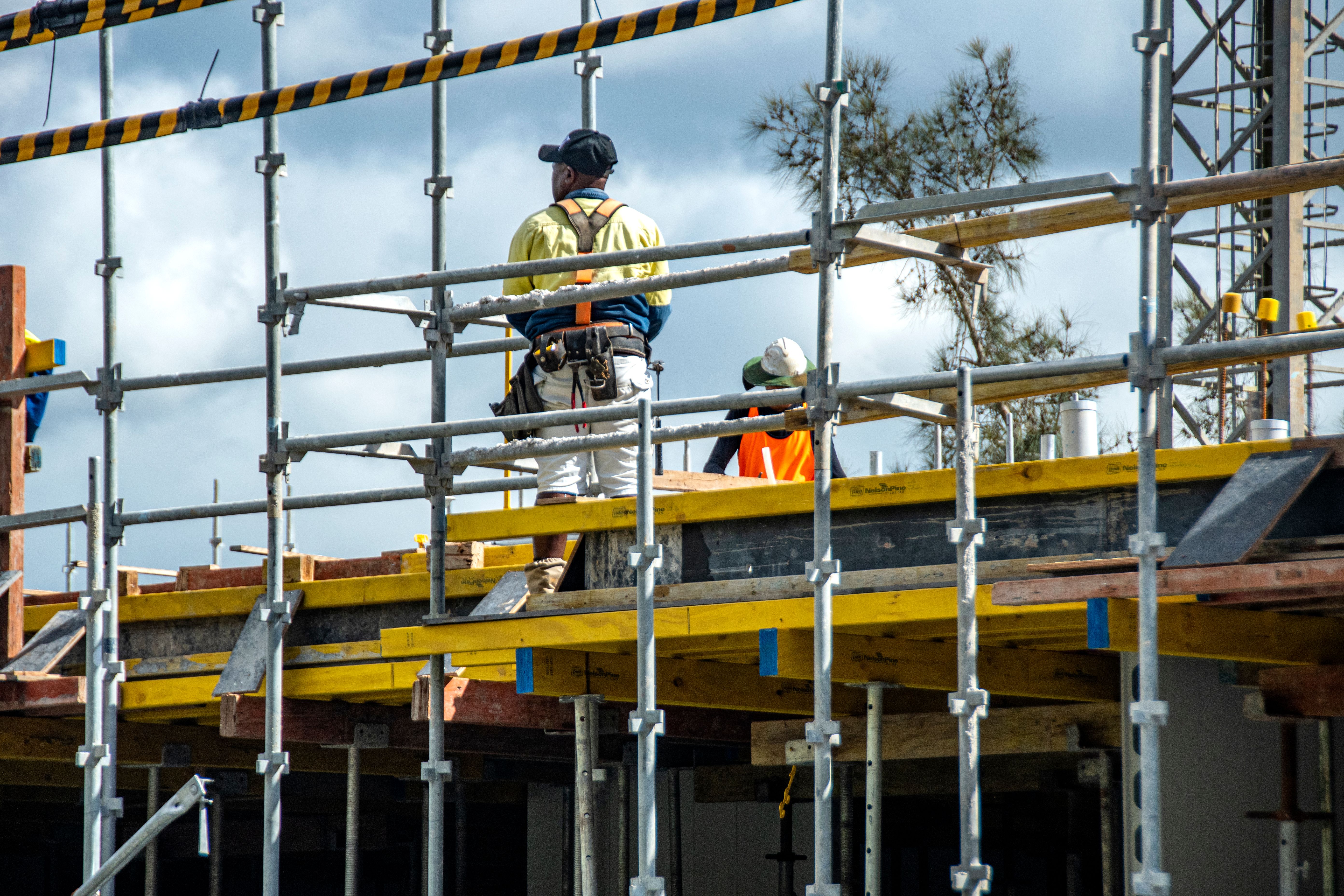 Worker assembling floor formwork on new social housing home unit block at 56-58 Beane St. Gosford, Australia. March 7, 2021. Part of a series.