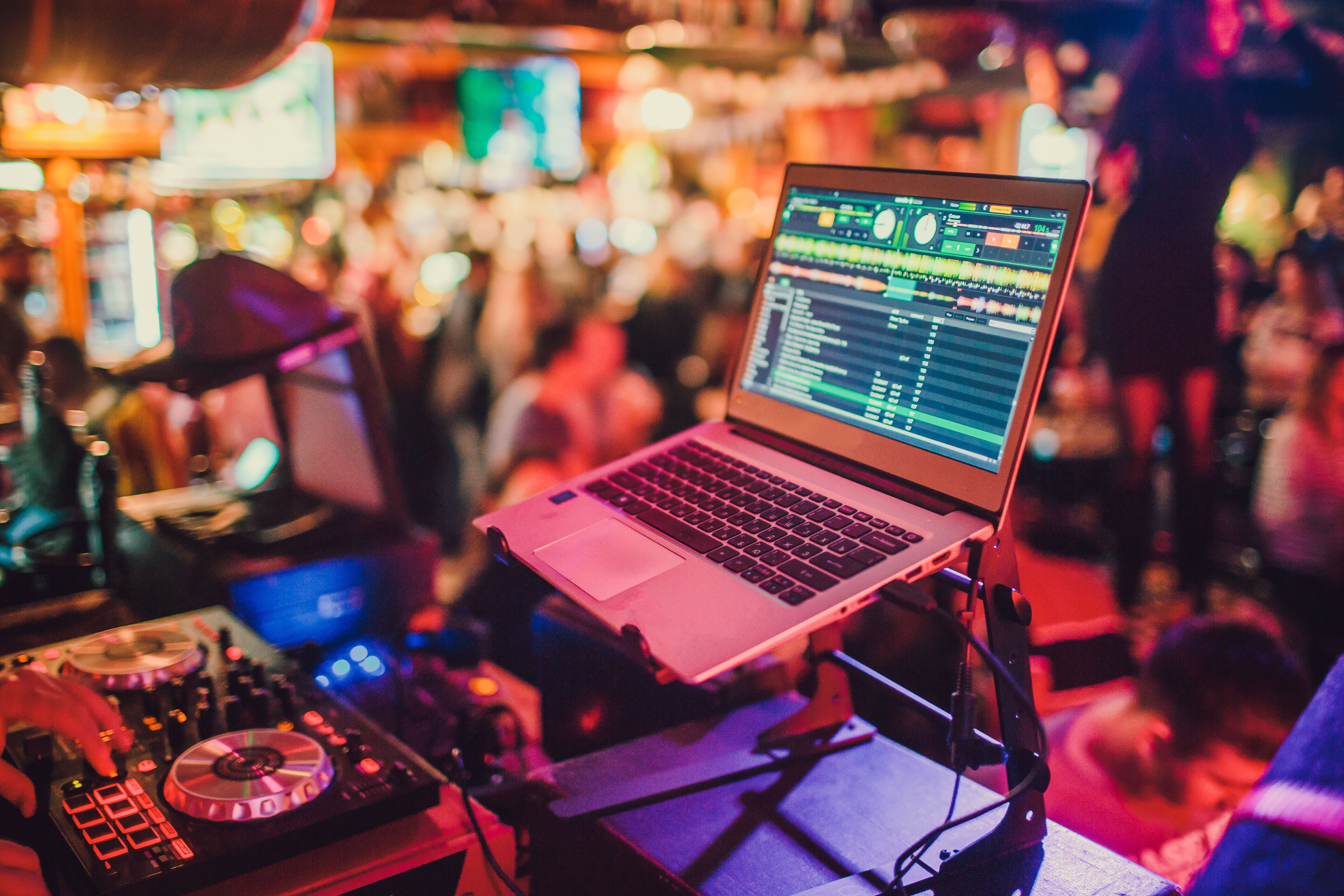 DJ mixing tracks on a mixer in a nightclub.