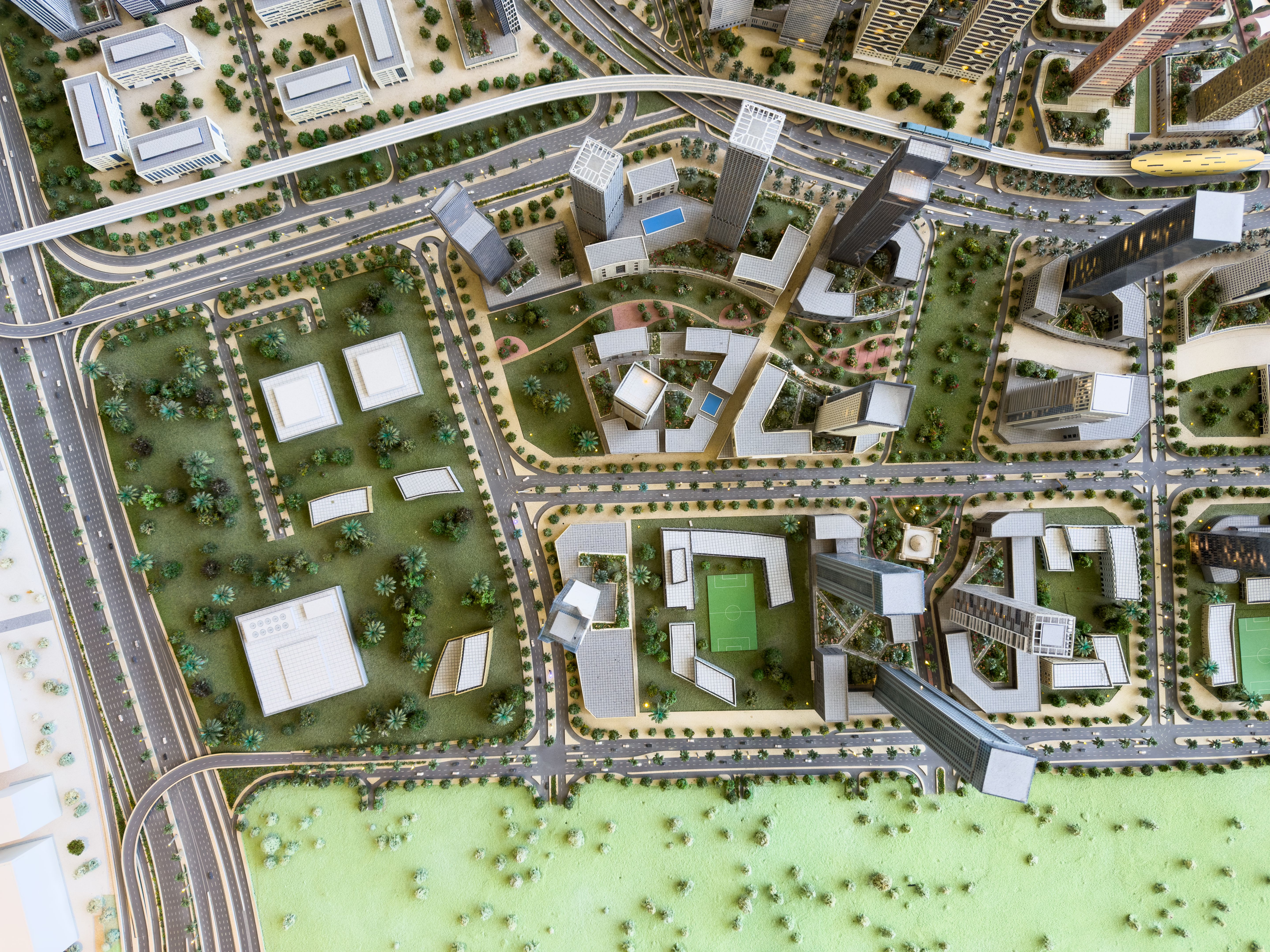 Aerial view of modern highway interchange with green landscaping , buildings and illuminated roads for urban planning and transportation design concepts