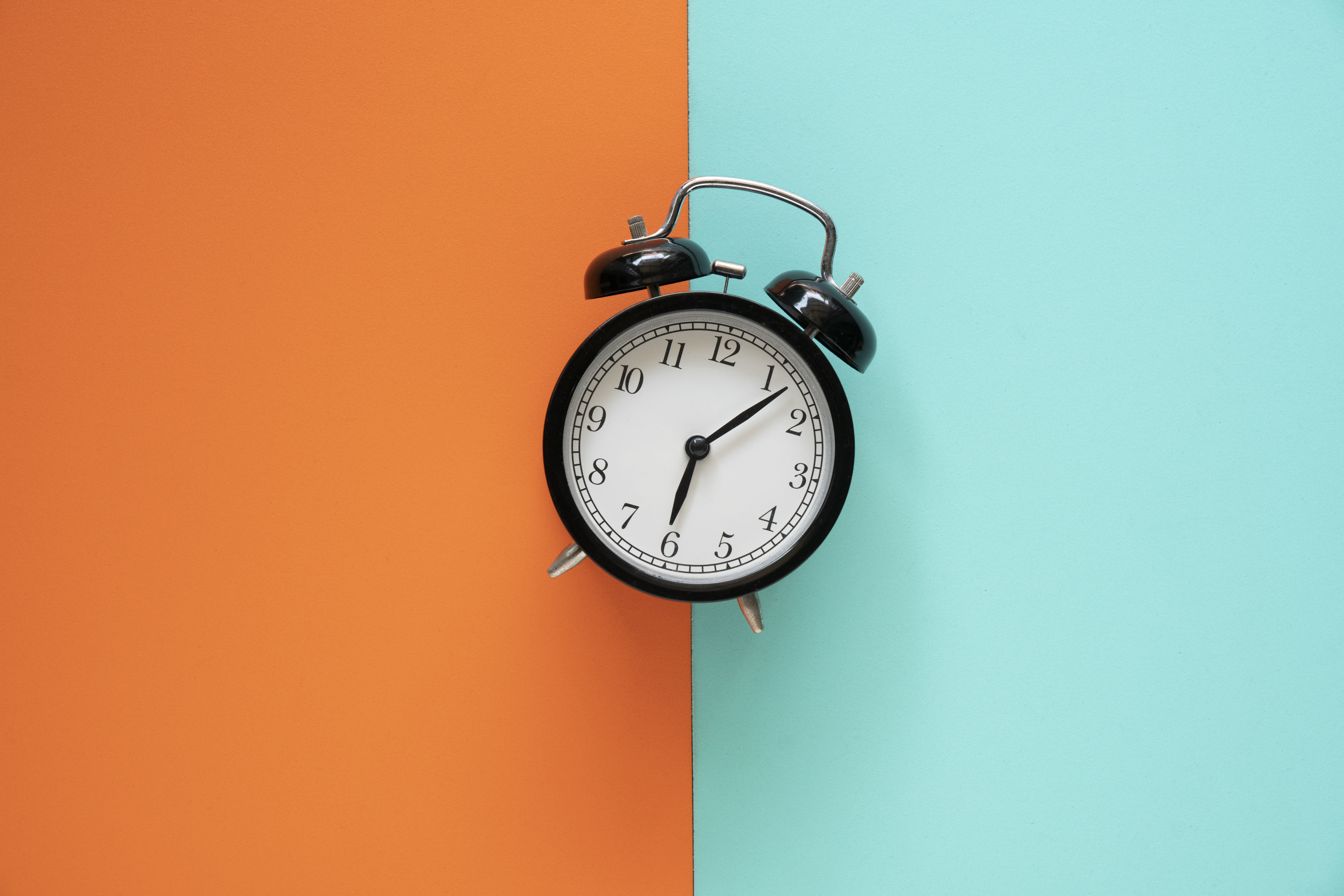 Retro alarm clock on color table background, vintage style