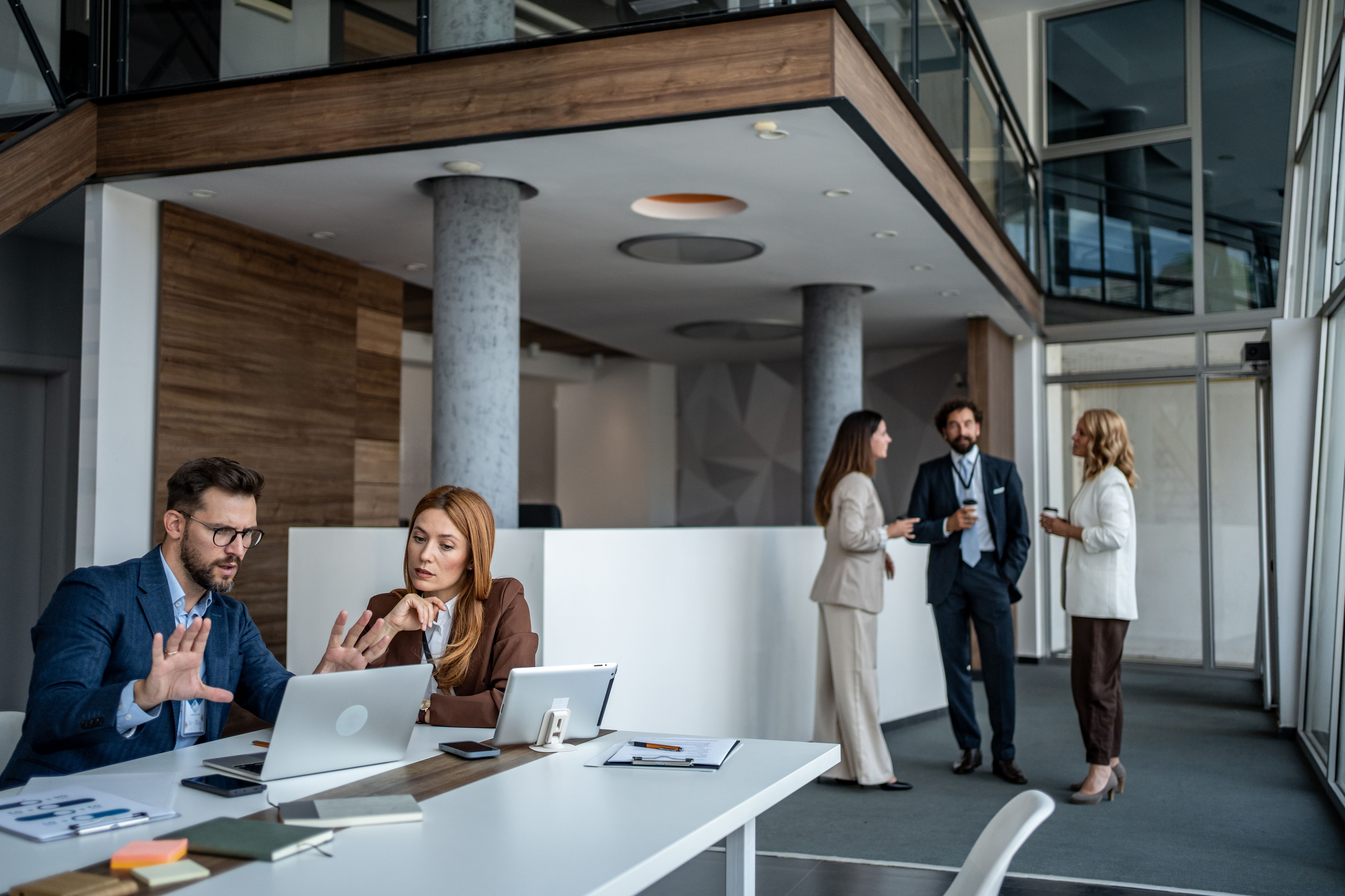Business professionals collaborating in modern office setting discussing project