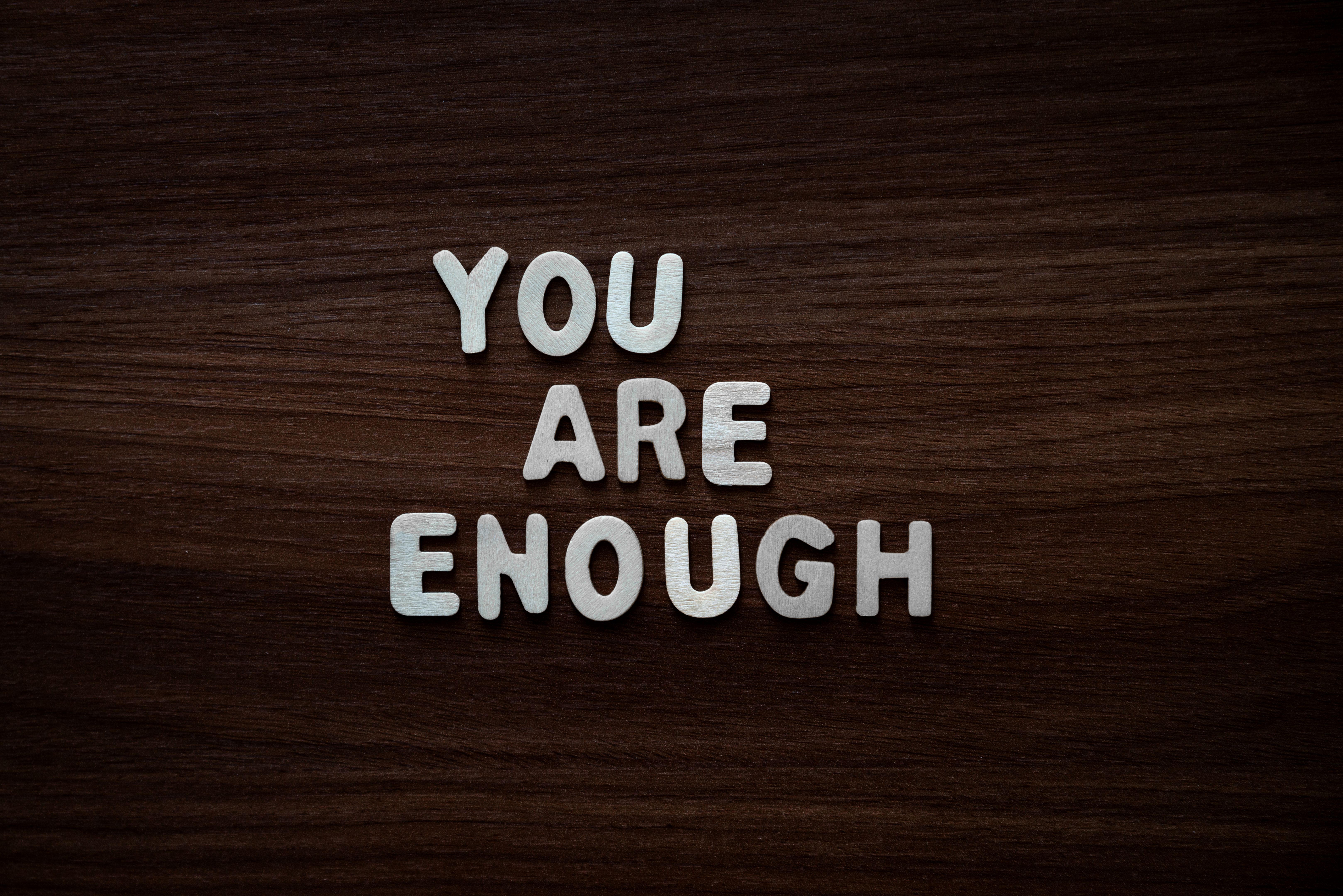 You are enough - Wooden letters on walnut background