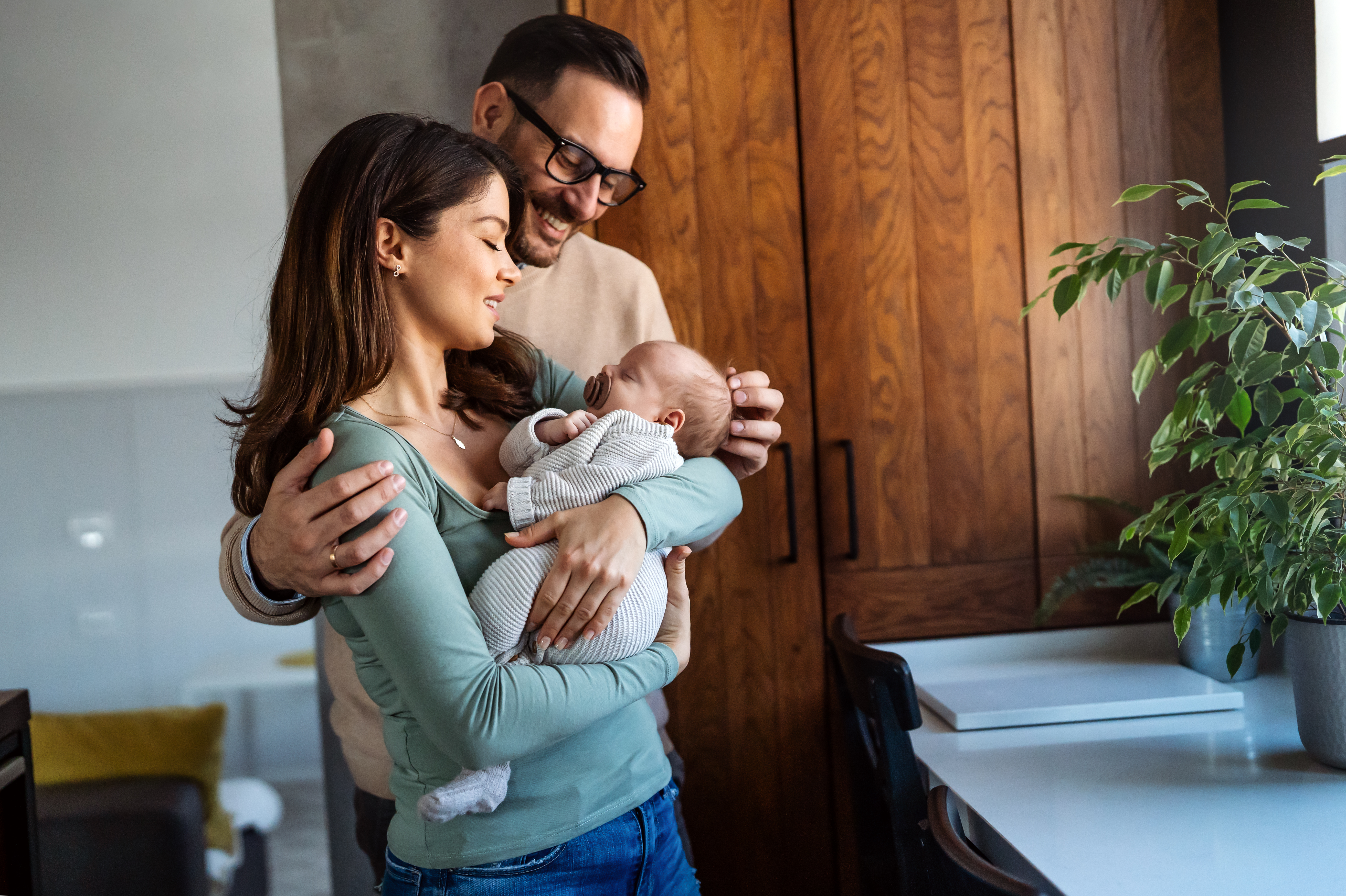Portrait of young happy man and woman holding newborn cute babe dressed in white unisex clothing. Portrait of young happy man and woman holding newborn cute babe dressed in white unisex clothing.