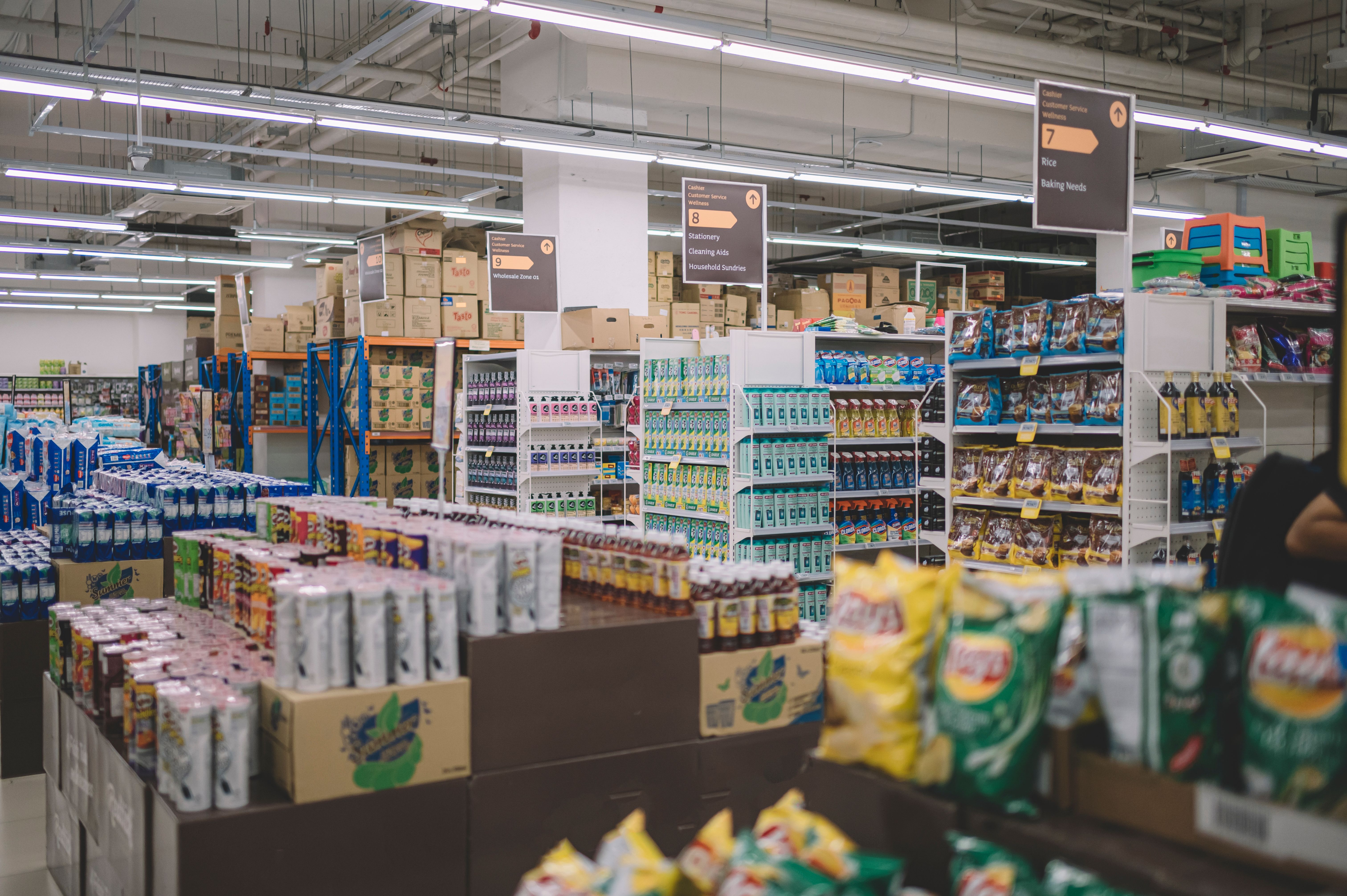 interior of supermarket full of grocery items in rows with shelf displayed