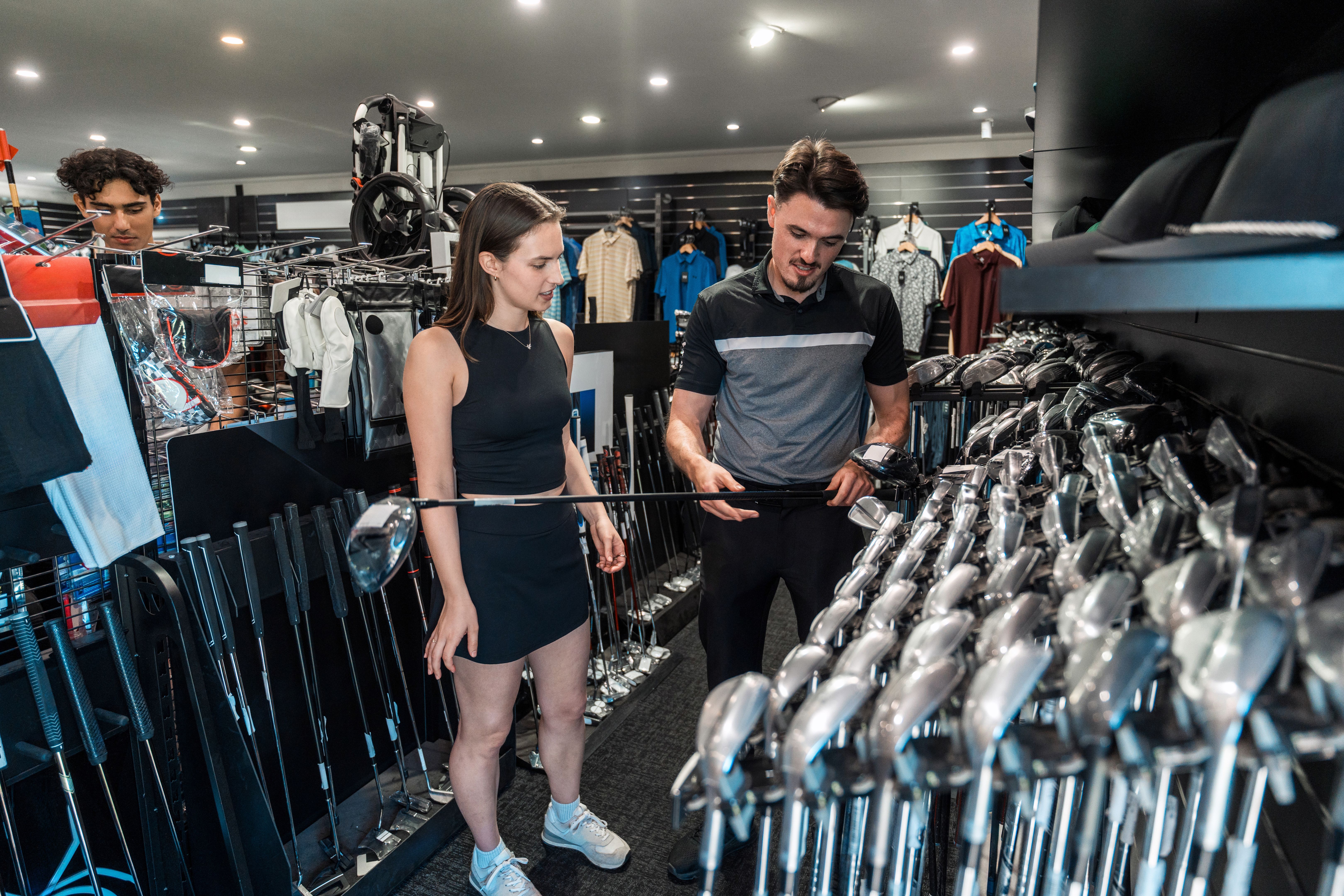Enthusiastic Caucasian Female Selects Golf Club with Expert Guidance