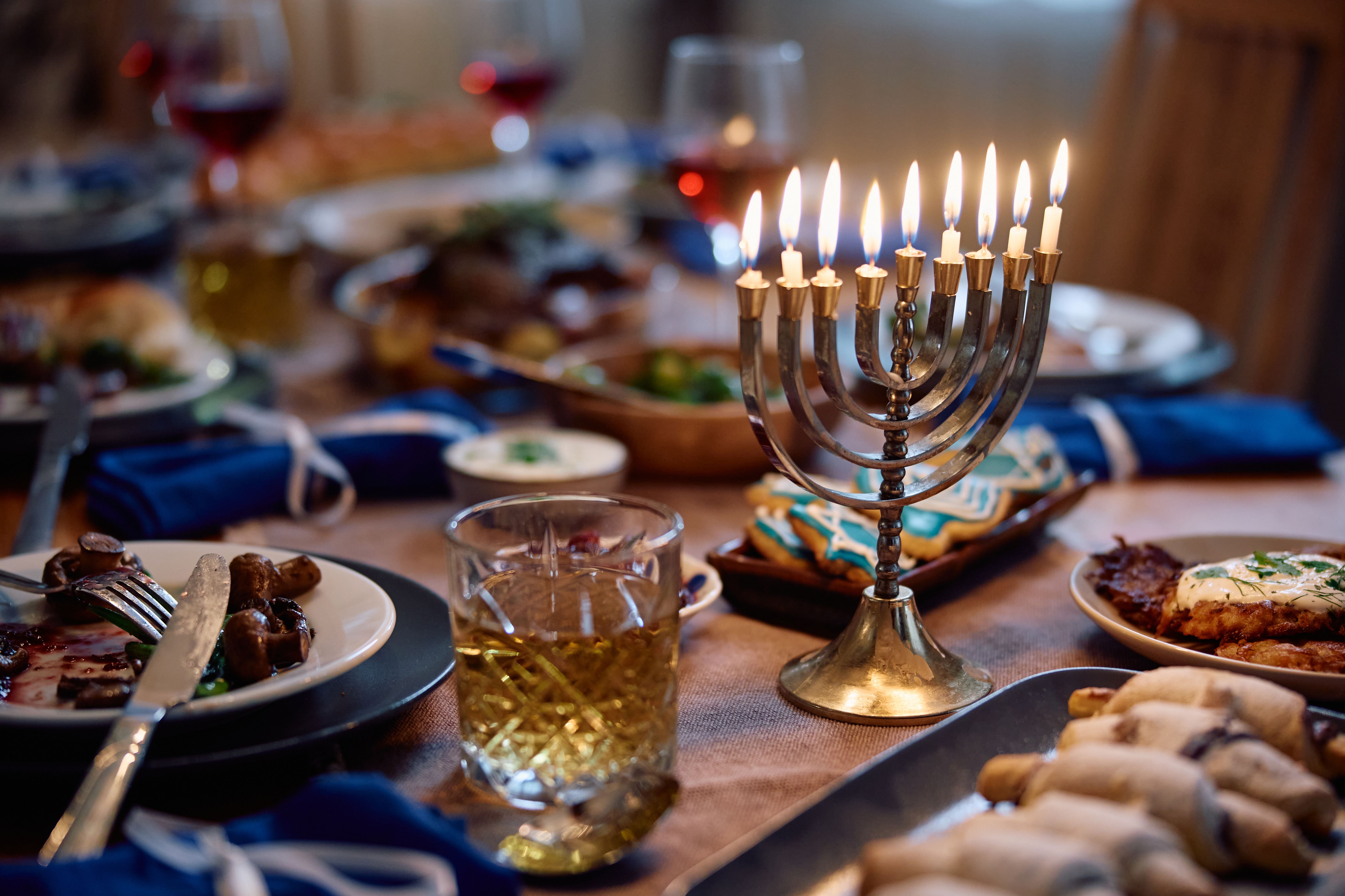 Lit candles in menorah during Hanukkah meal at home.