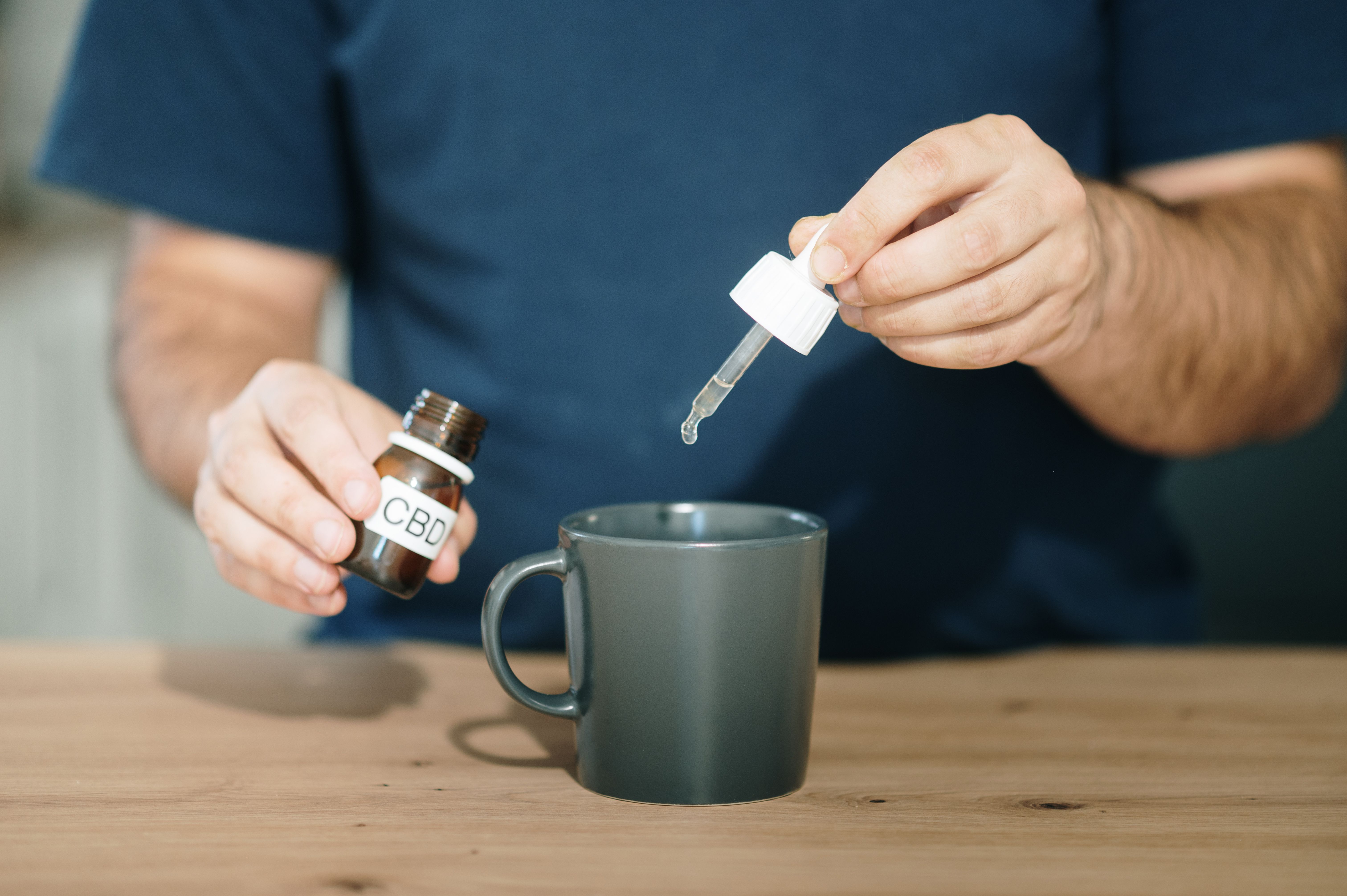 Pouring CBD oil into a cup
