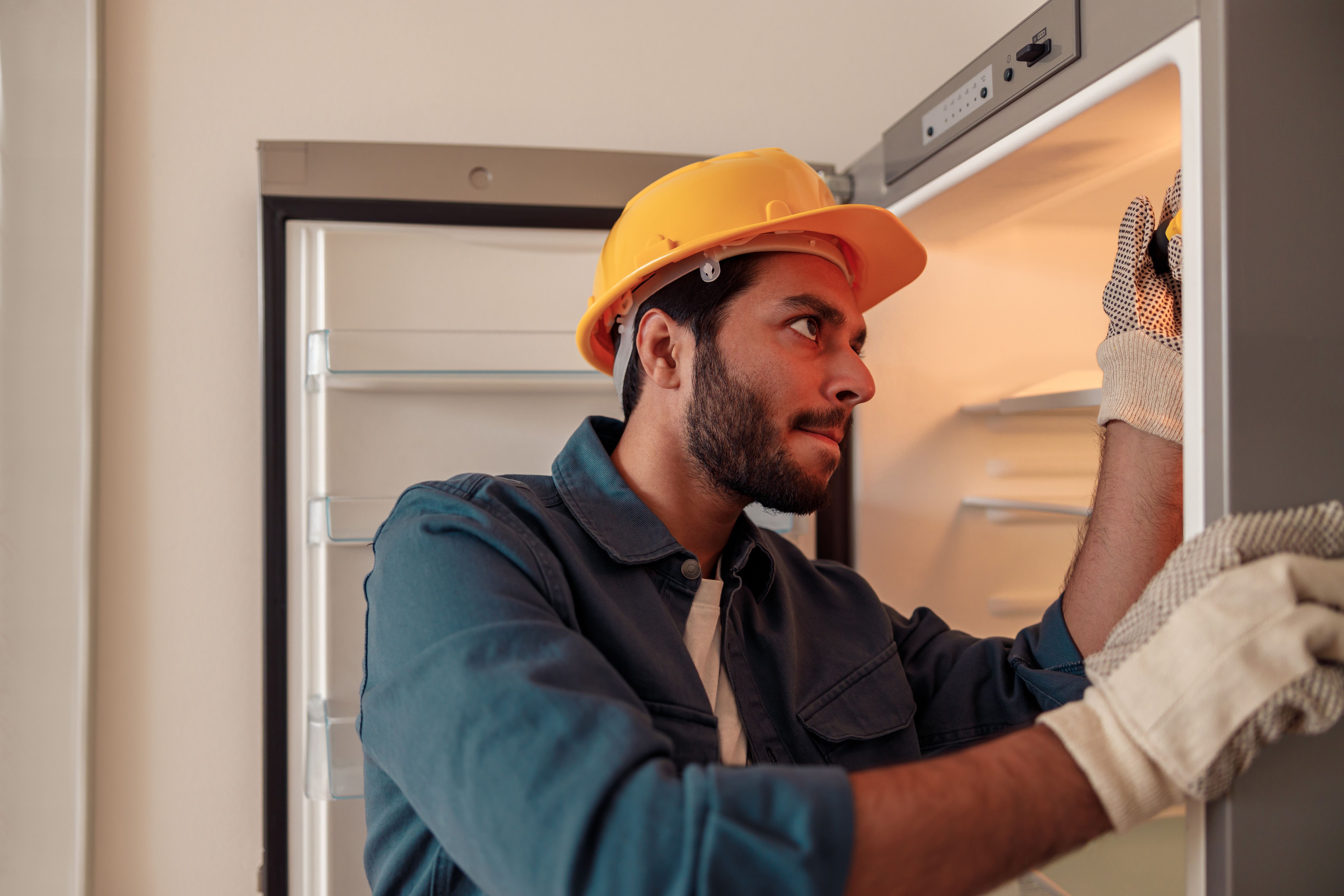 technician repairing refrigerator