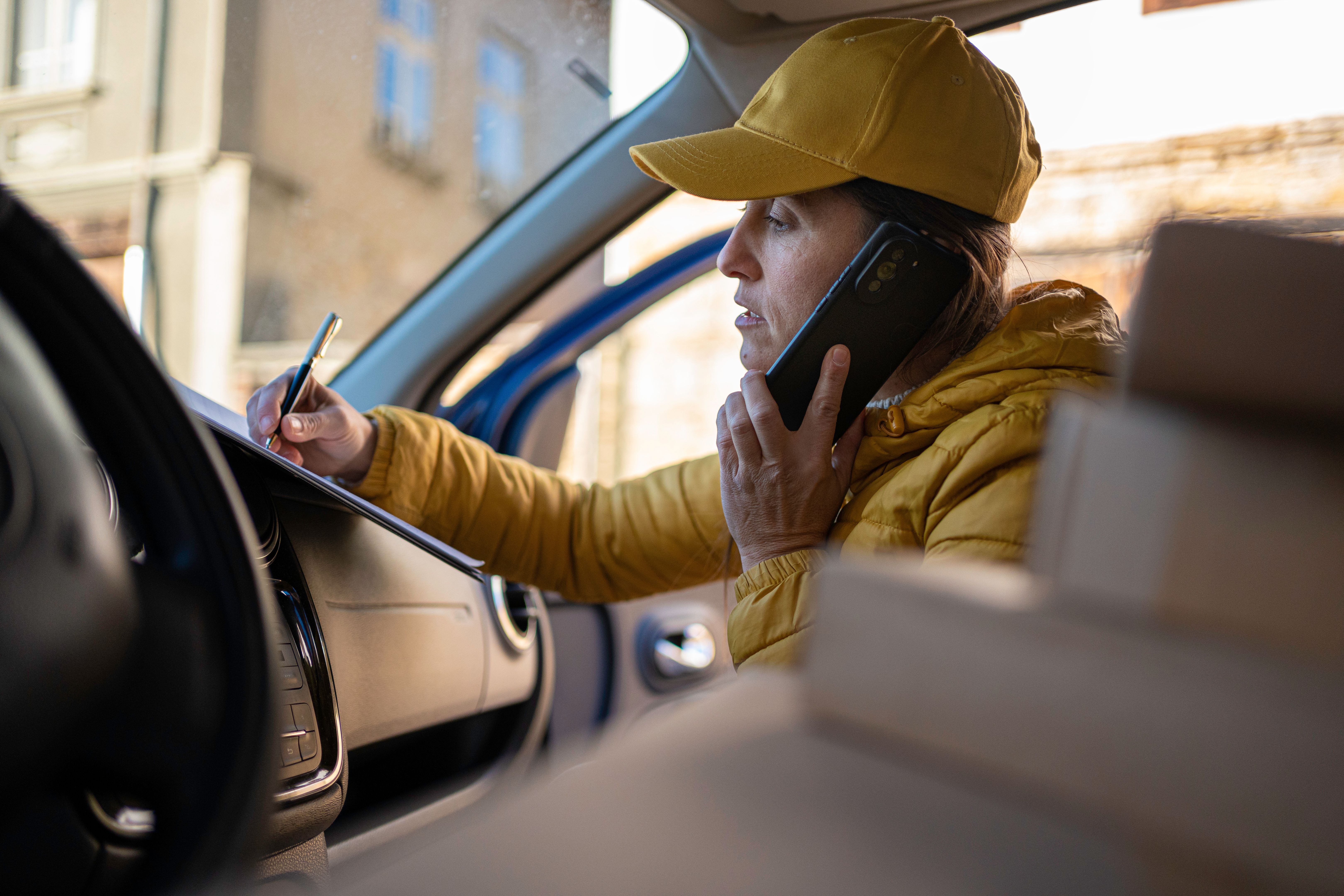 Gig Workers. Female Delivery Driver Talks on Phone. Gig Workers. Female Delivery Driver Talks on Phone.