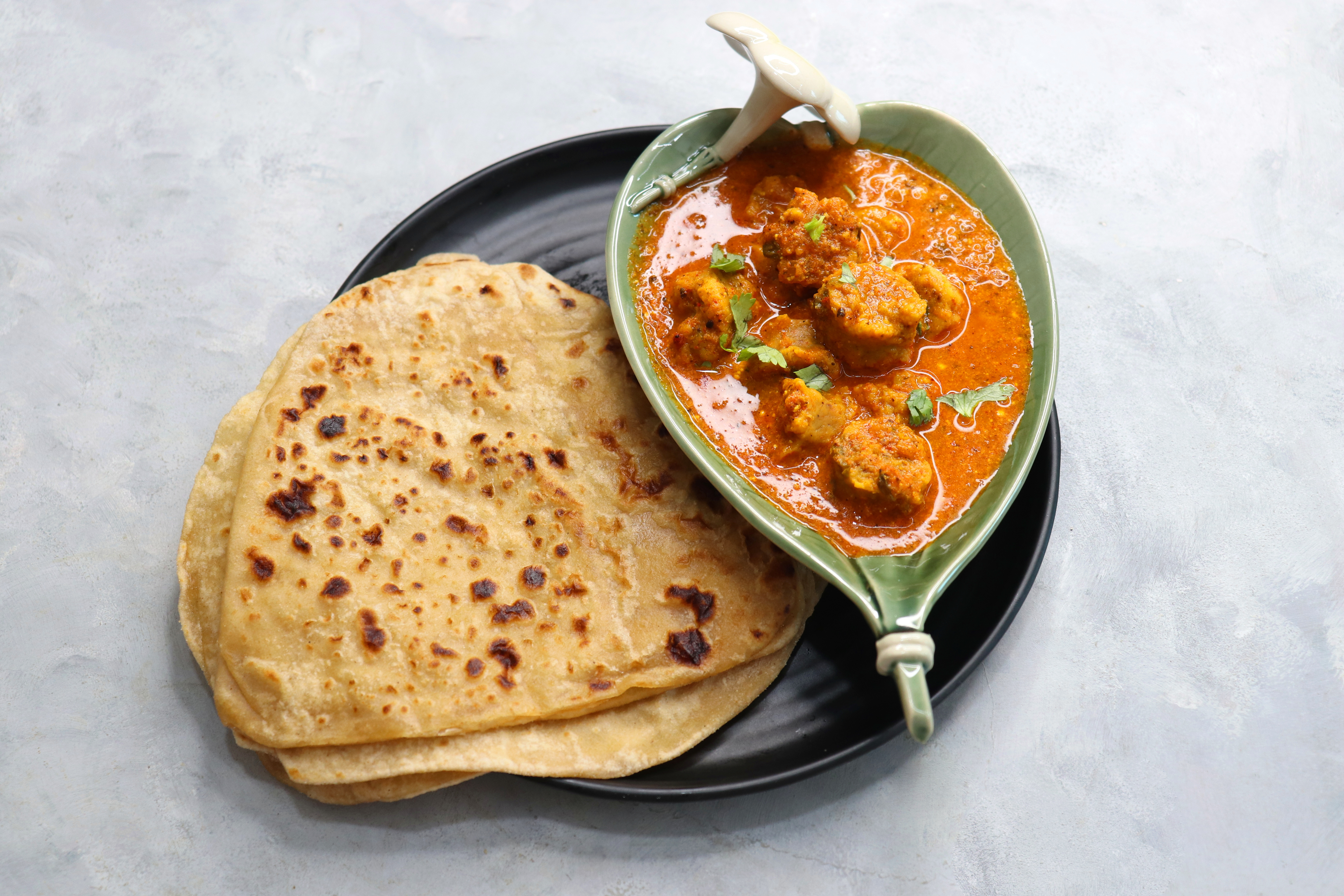Rajasthani Gatta Curry or Besan Ke Gatte Ki Sabzi. Gatte are gram flour roundels or chickpea flour dumplings are cooked in a spicy, tangy yogurt based curry. delicacy of Rajasthan, India. copy space.