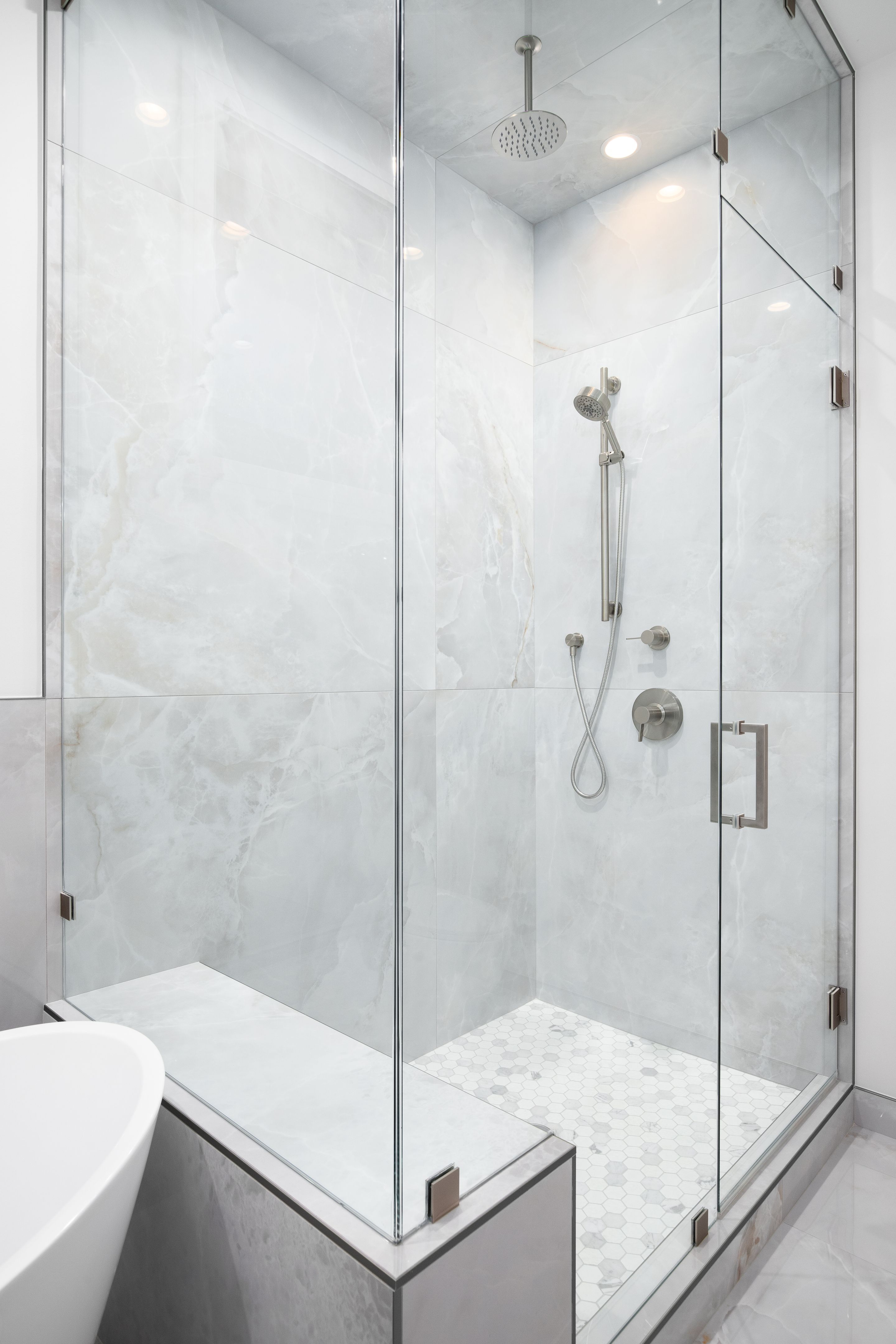 A walk-in shower with marble tiles.