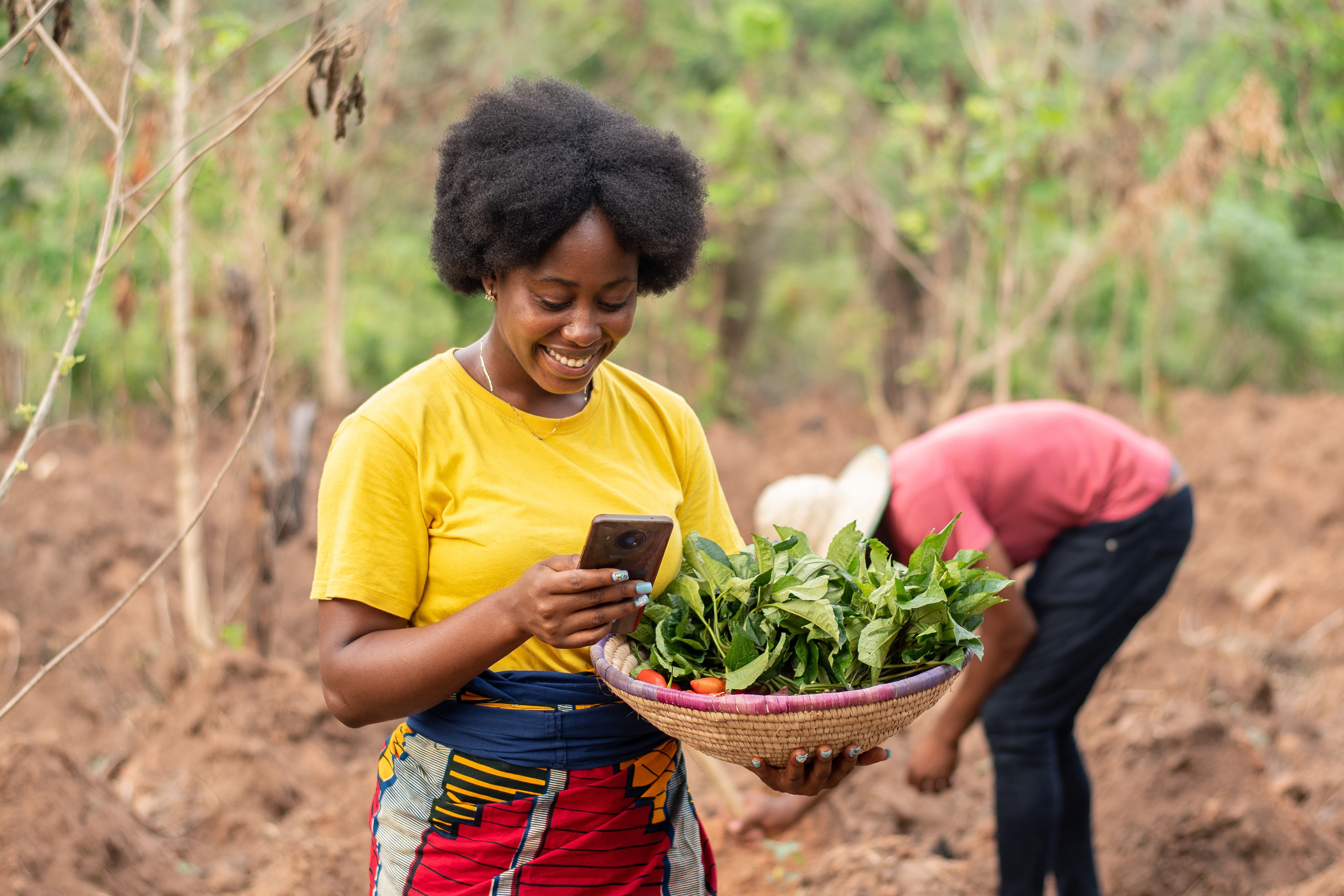 african farmer making use of her phone