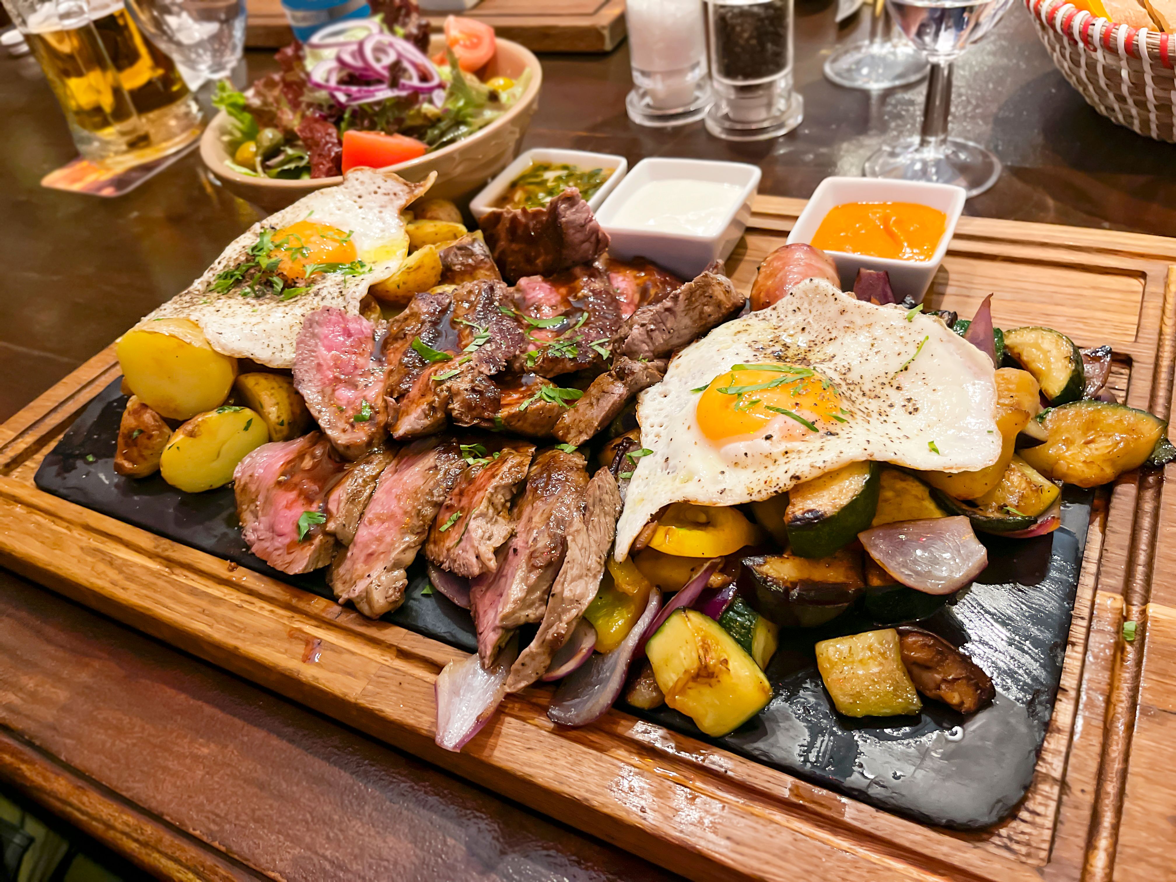 Argentine style steak with potatoes, eggs and vegetables and a variety of dipping sauces