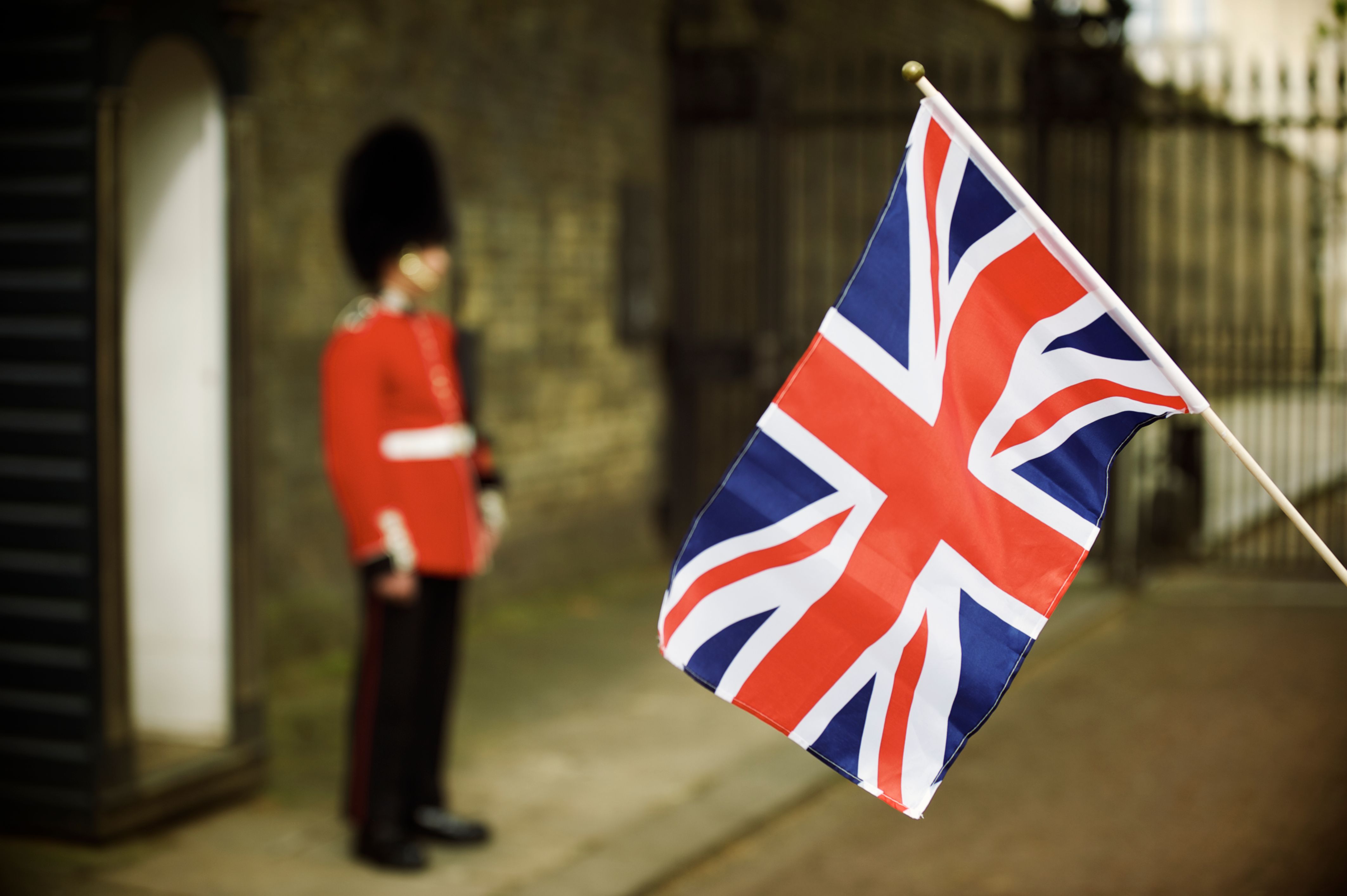 Union Jack Flag Waves Next to Soldier in Red