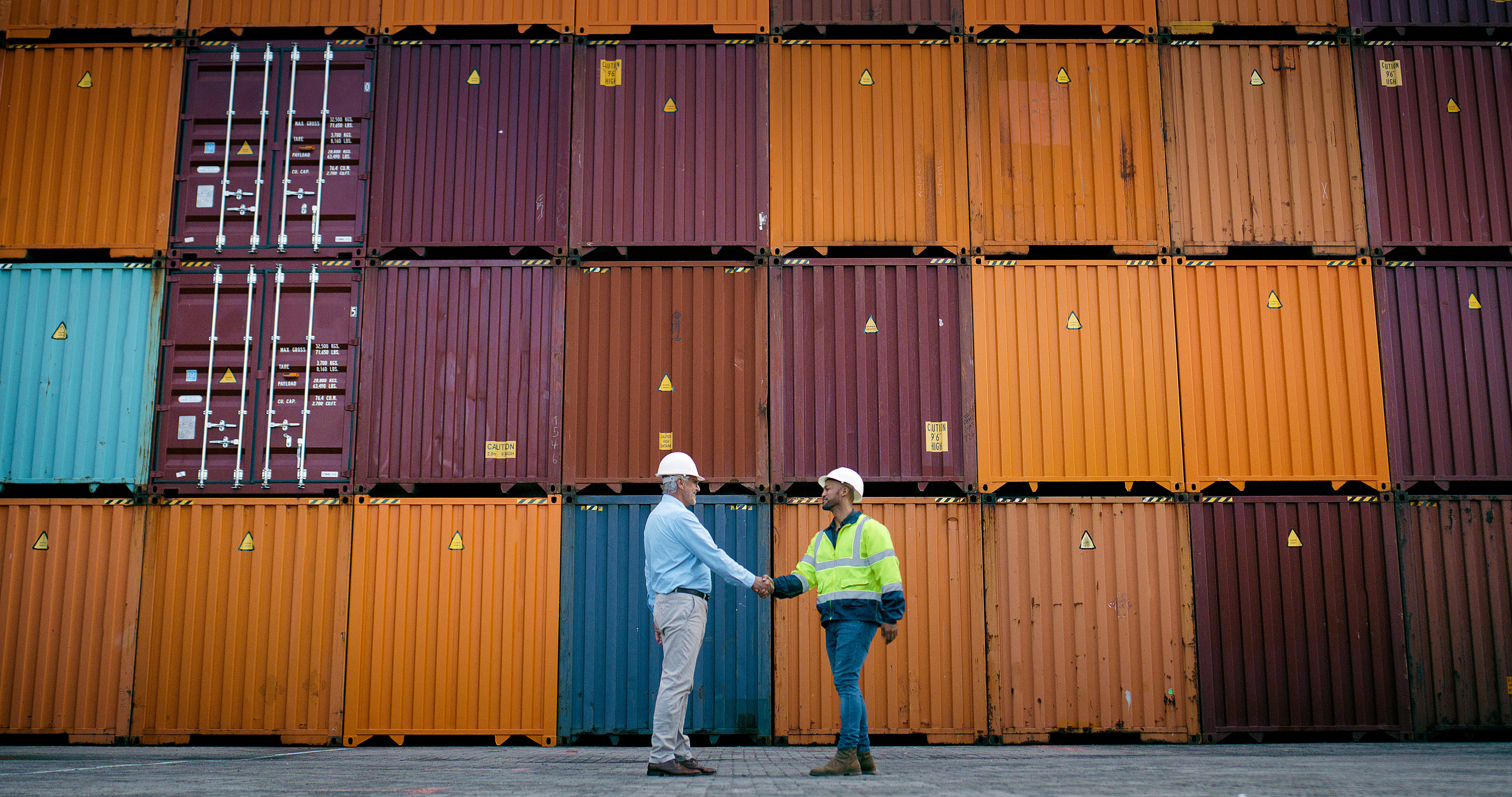 Business people, handshake and meeting with distributor for shipment, logistics or distribution at depot. Businessman shaking hands for stock partnership or shipping in container yard or storage Business people, handshake and meeting with distributor for shipment, logistics or distribution at depot. Businessman shaking hands for stock partnership or shipping in container yard or storage