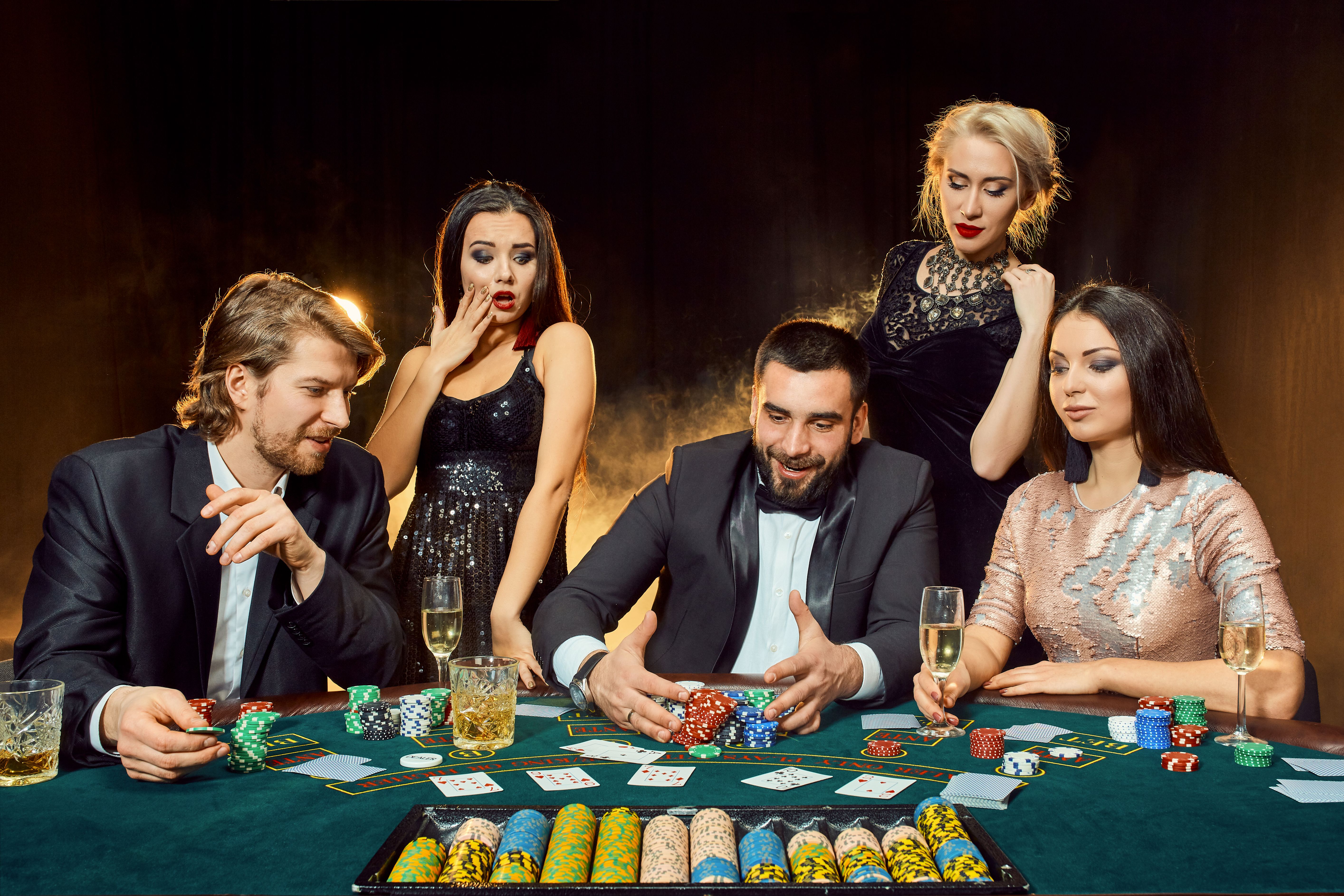 Poker players sitting around a table at a casino Poker players sitting around a table at a casino