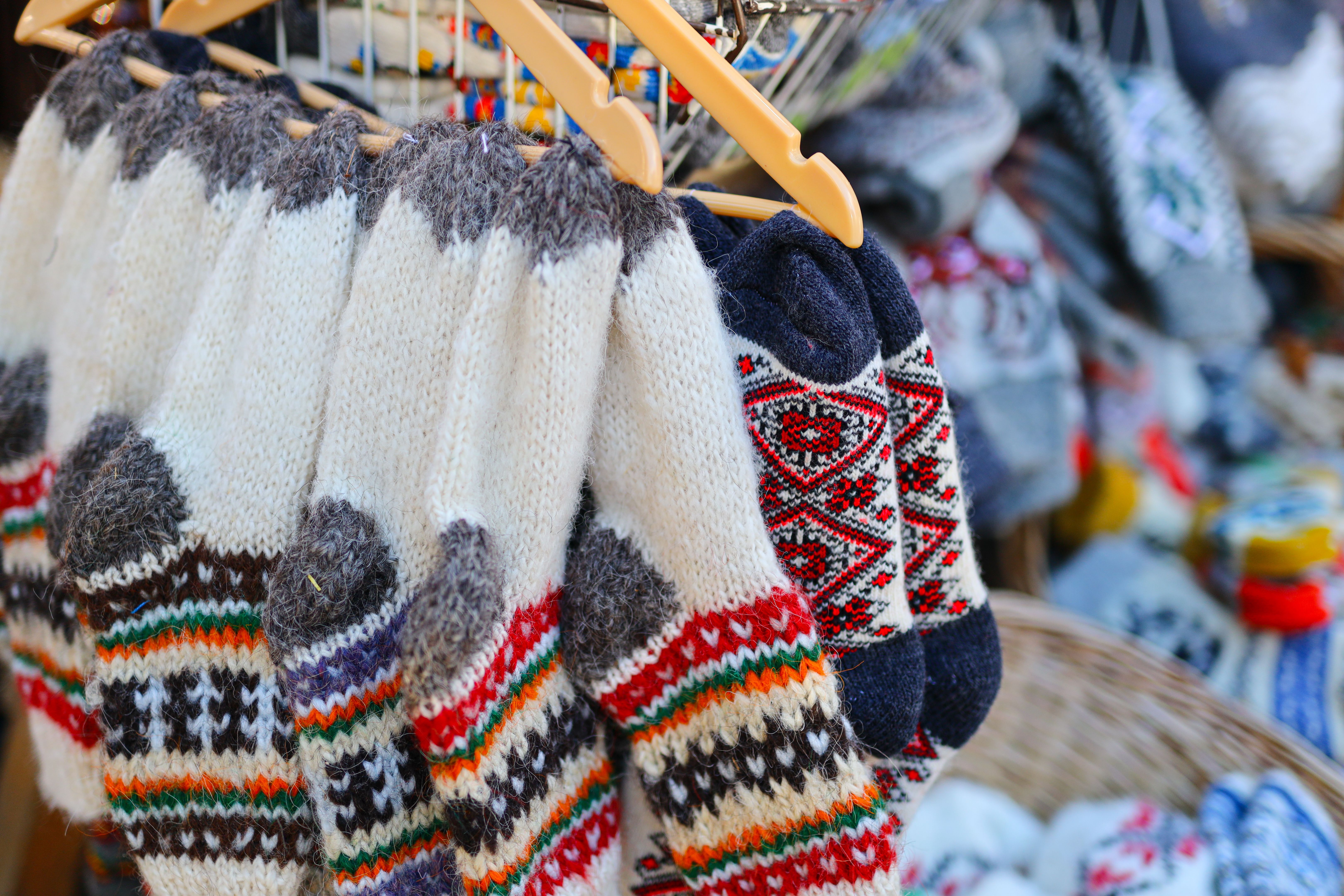 Colorful knitted socks and sweaters displayed at market stall Colorful knitted socks and sweaters displayed at market stall