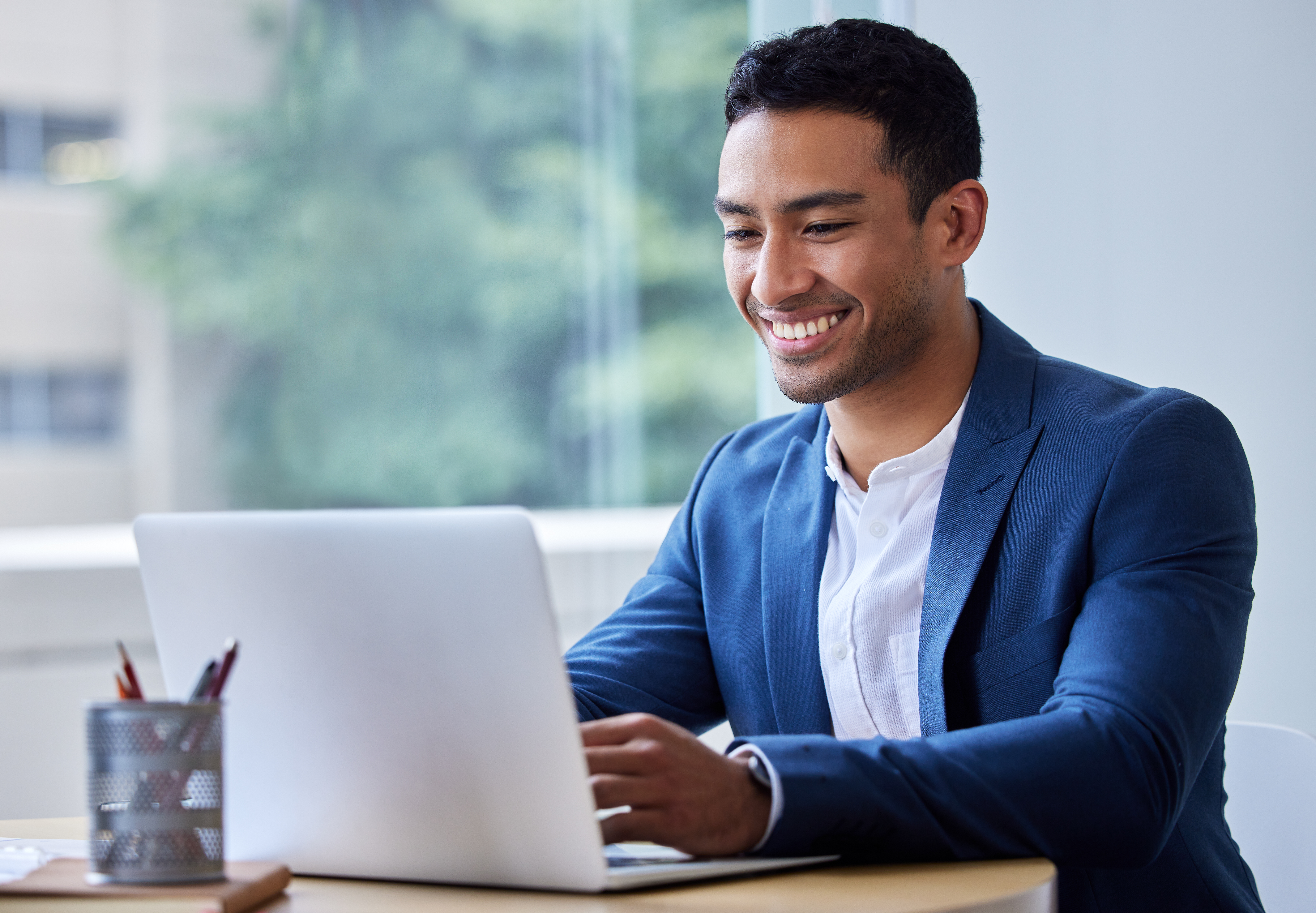 Shot of a young businessman working on his laptop Shot of a young businessman working on his laptop