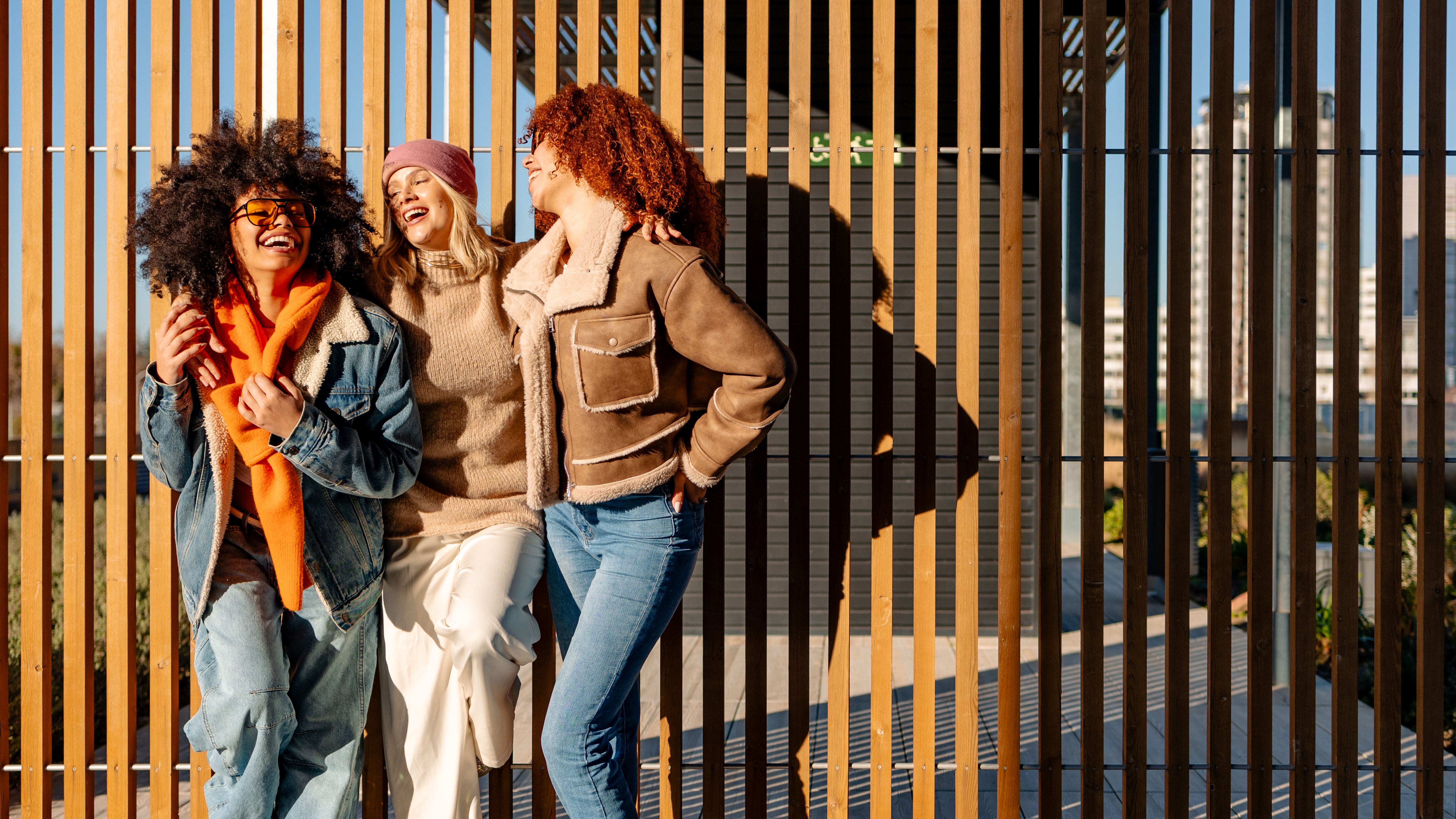 Three cheerful multi ethnic women having fun together outdoors, copy space Three cheerful multi ethnic women having fun together outdoors, copy space