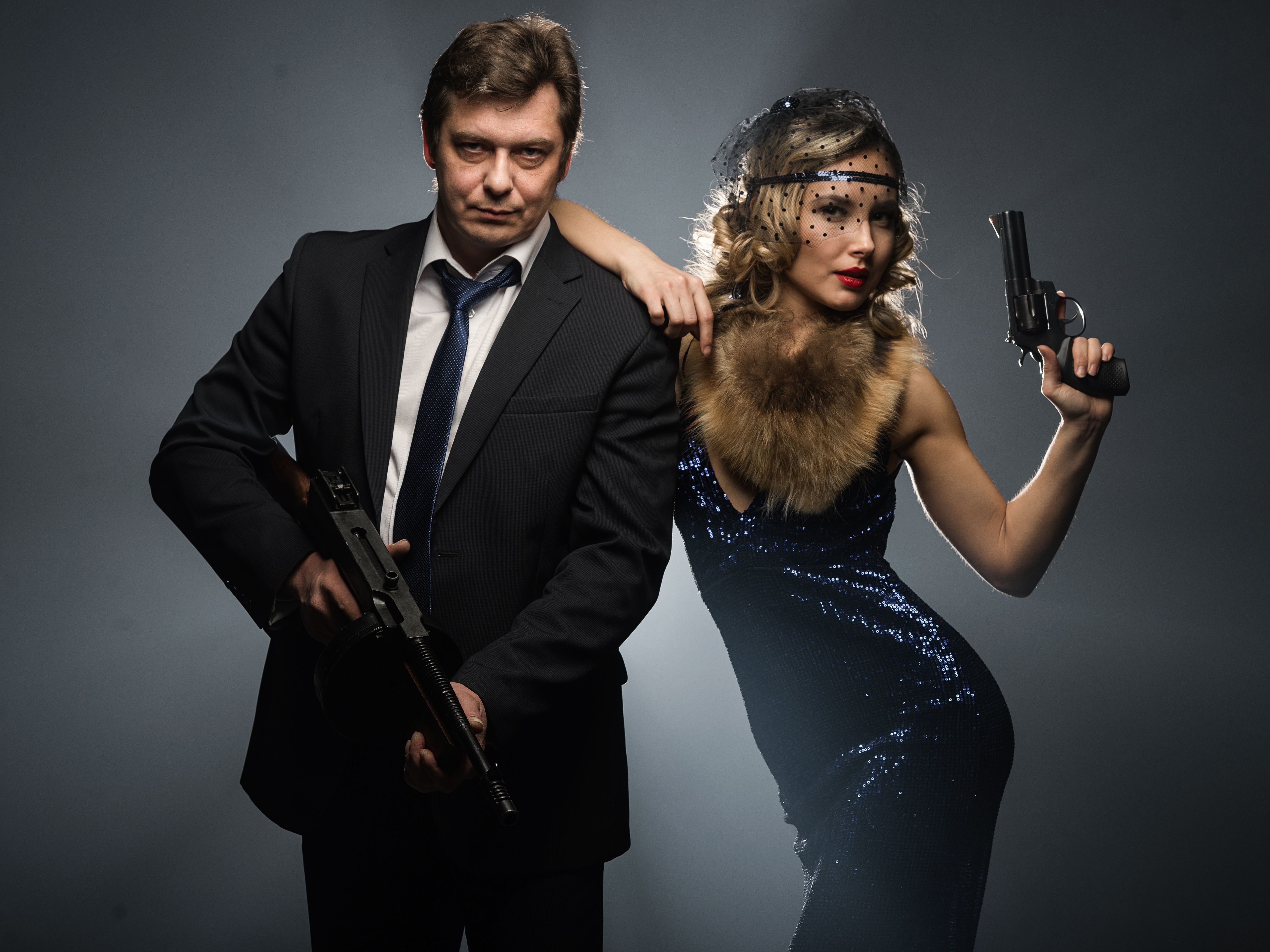 A pair of gangsters, a man and woman with guns