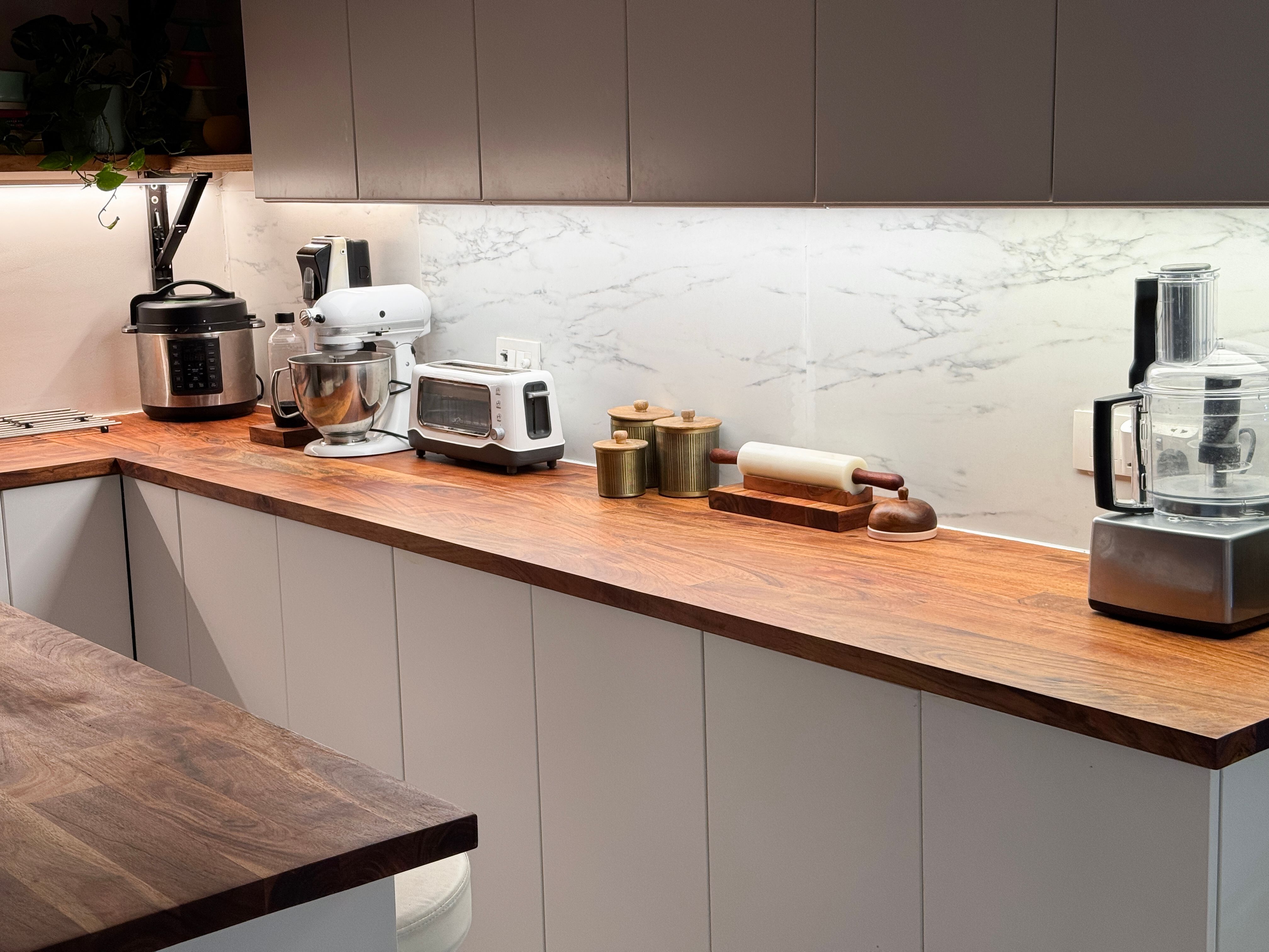 Image of contemporary kitchen with wooden surfaces, countertops, flooring, island, under-cabinet lighting, ambient kitchen lights