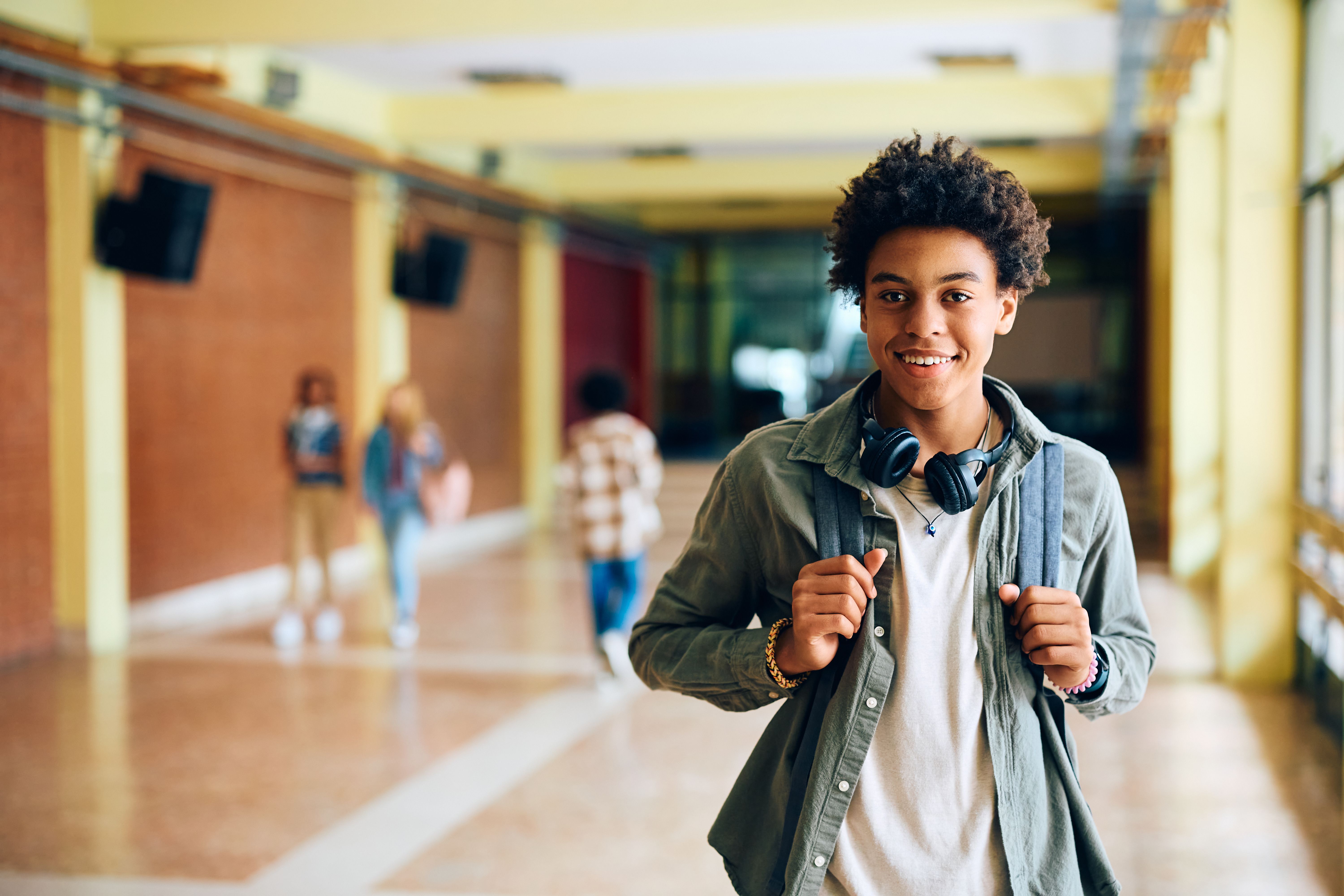 Happy black student in high school looking at camera.
