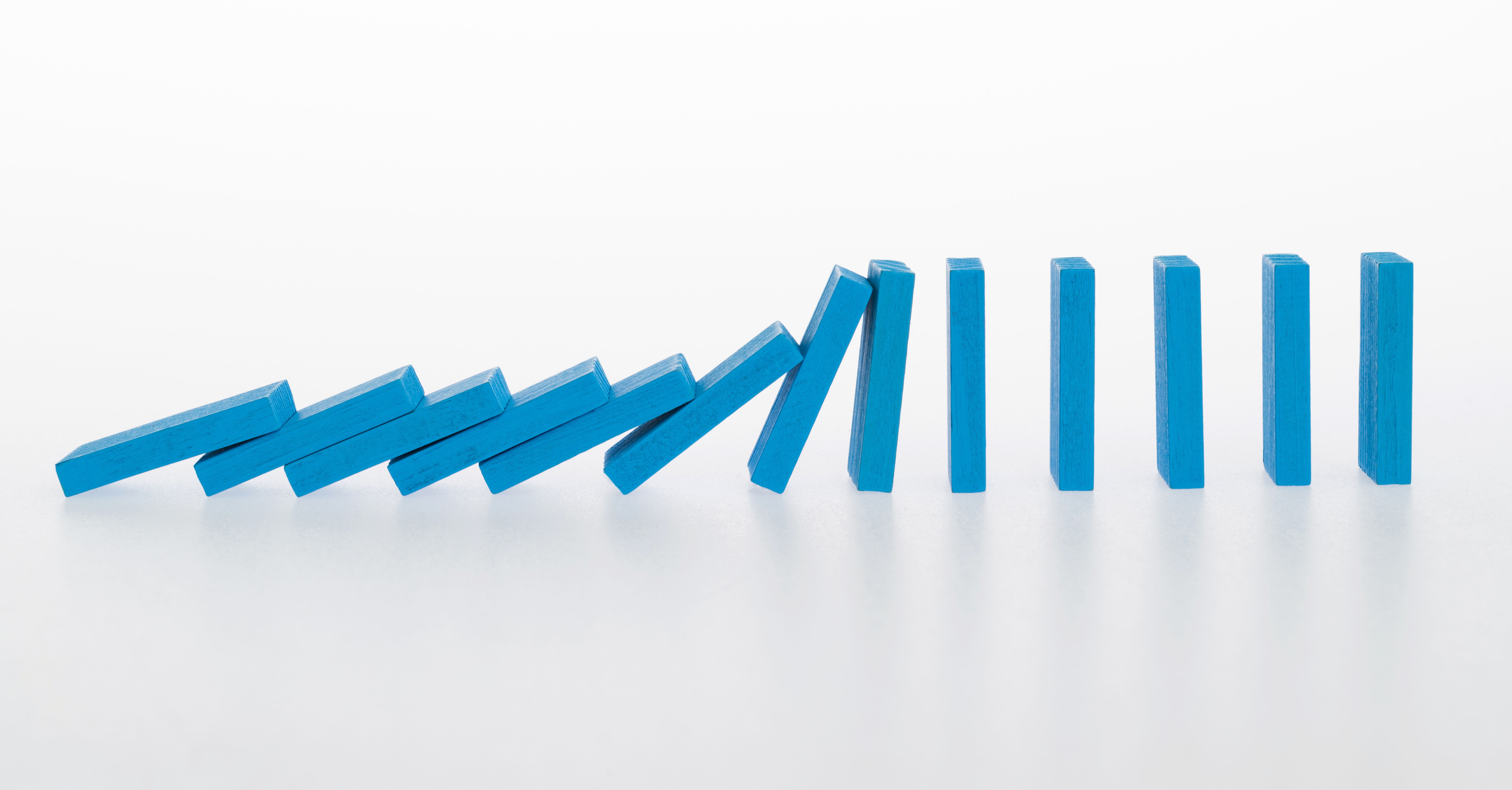 Falling dominoes on white background