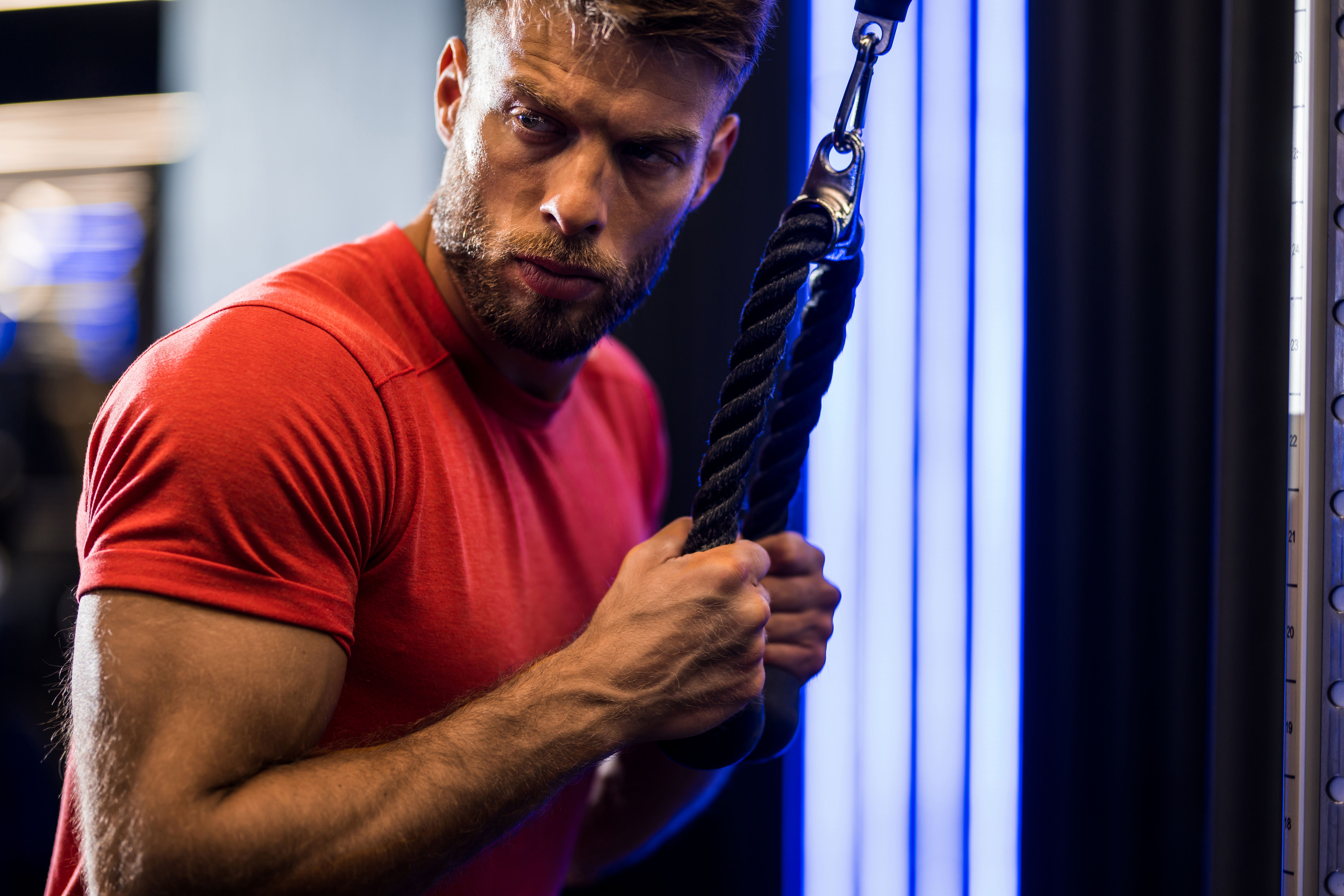 Athletic man doing triceps workout at the gym.