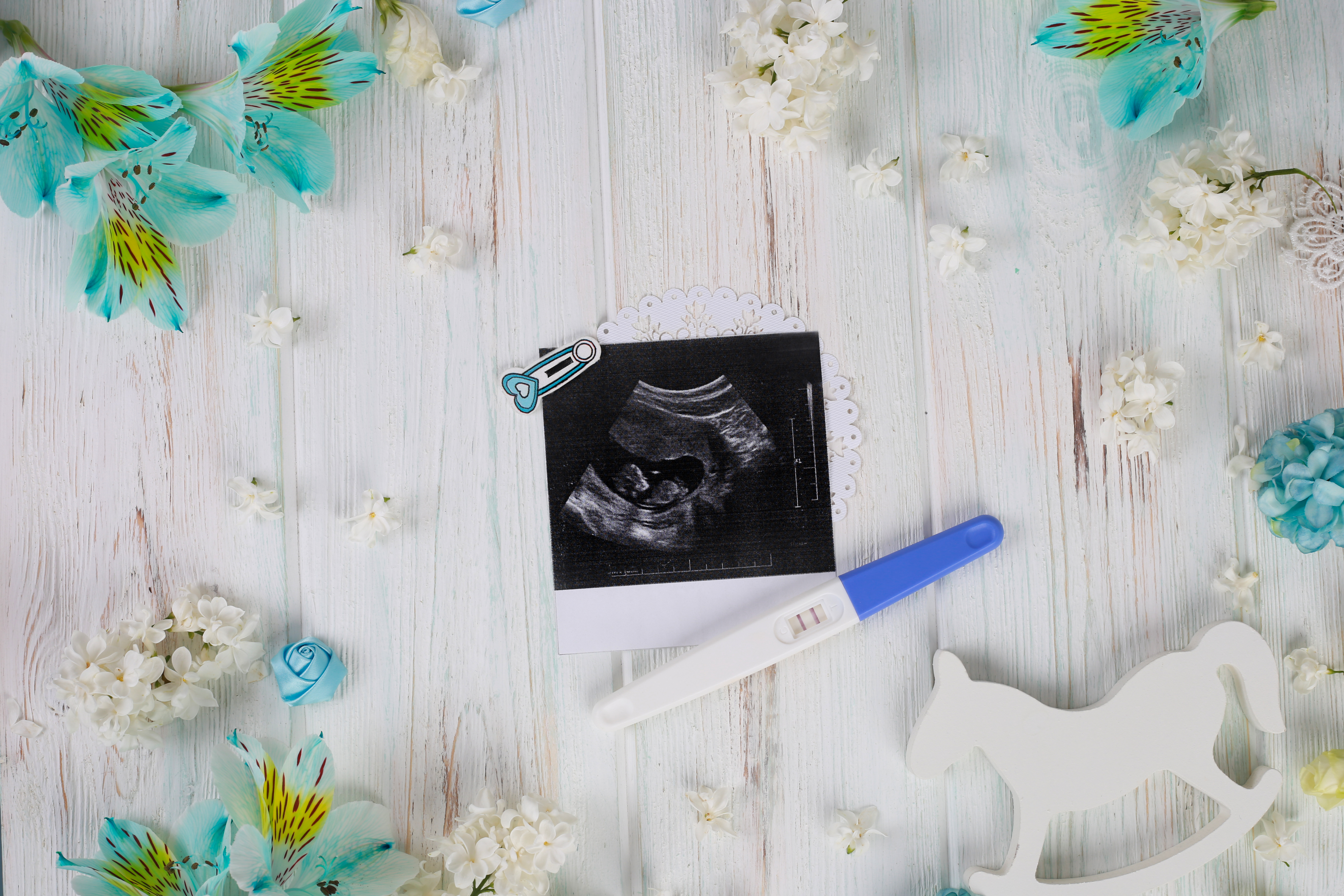 Baby ultrasound and pregnancy test on wood background. Child planning. Pregnancy concept. Baby ultrasound and pregnancy test on wood background. Child planning. Pregnancy concept.
