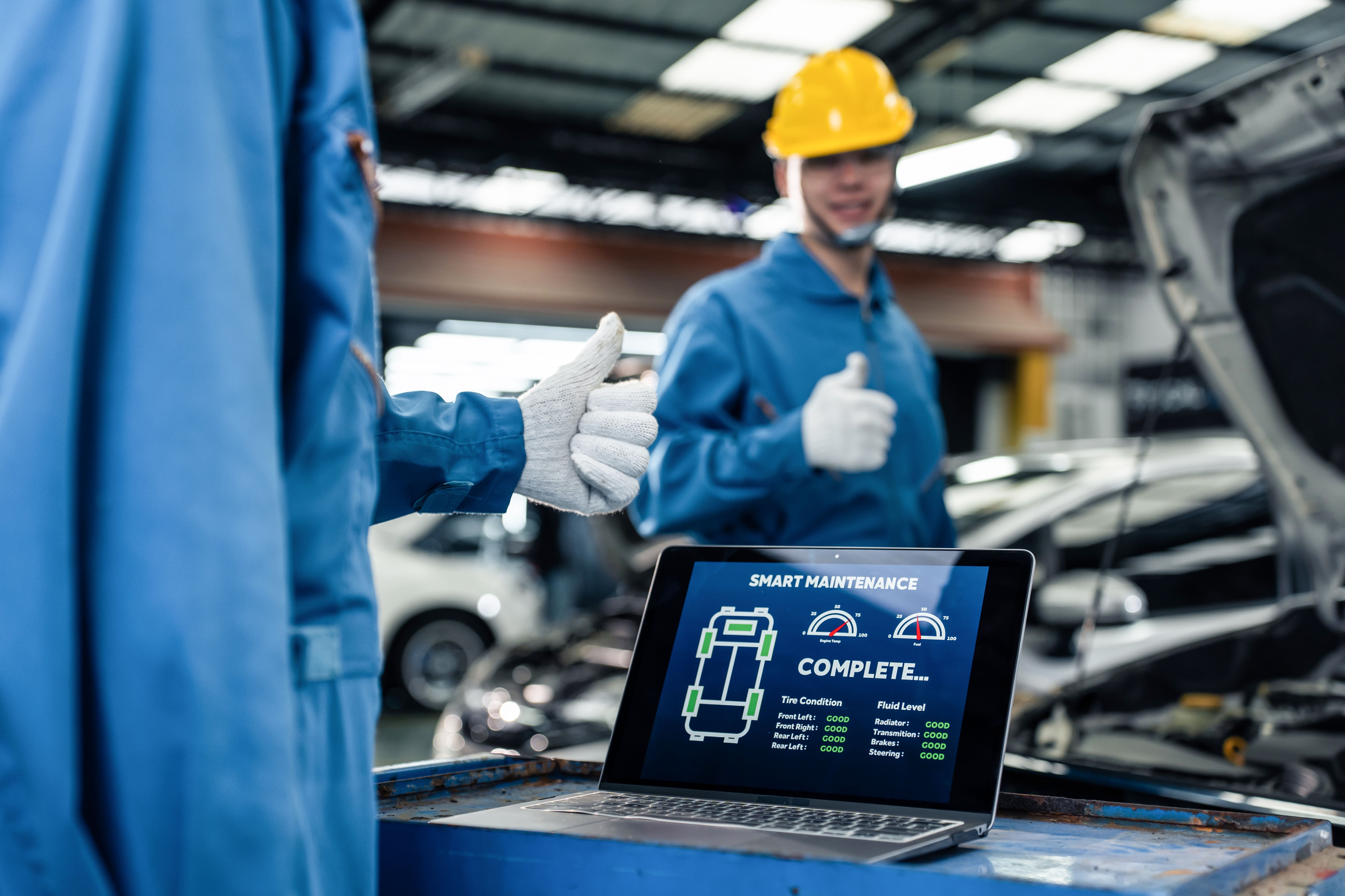 Close up of Automotive mechanic running diagnostics software on tablet. Asian young vehicle service manager worker work in mechanics garage, check and maintenance to repair the engine car in workshop.