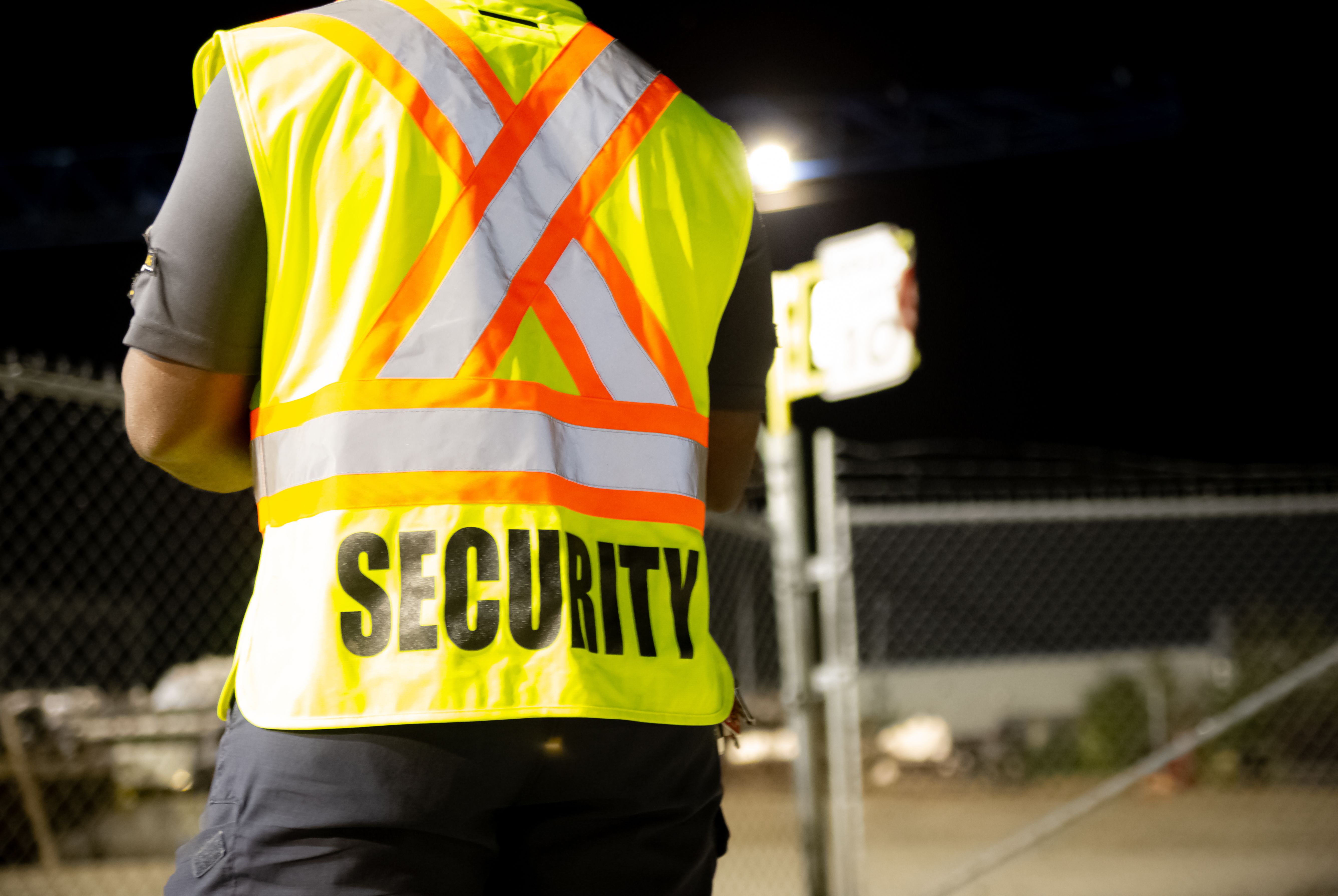 Security guard patrolling in fenced commercial area