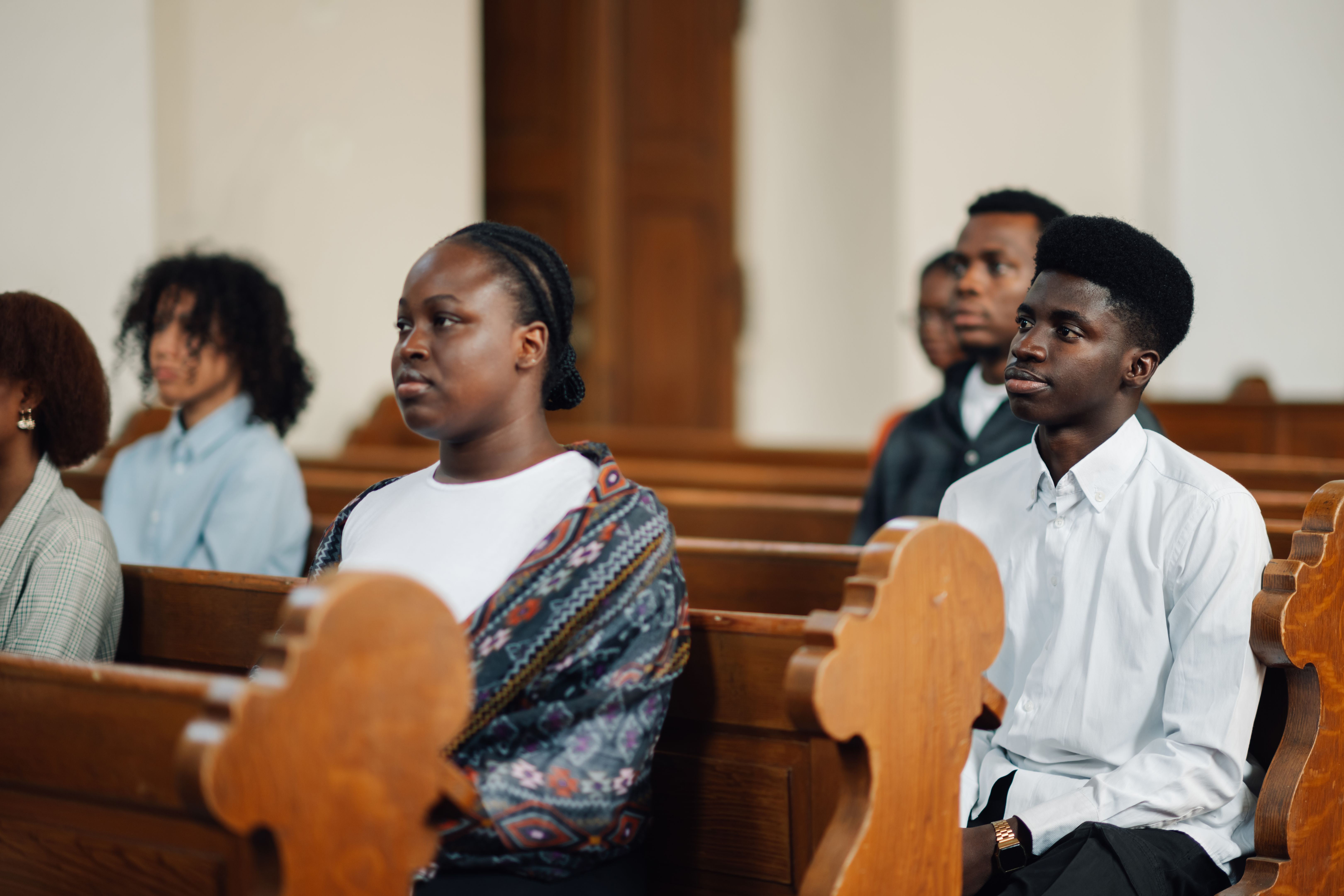 Group of people sitting in church pew listening to sermon Group of people sitting in church pew listening to sermon