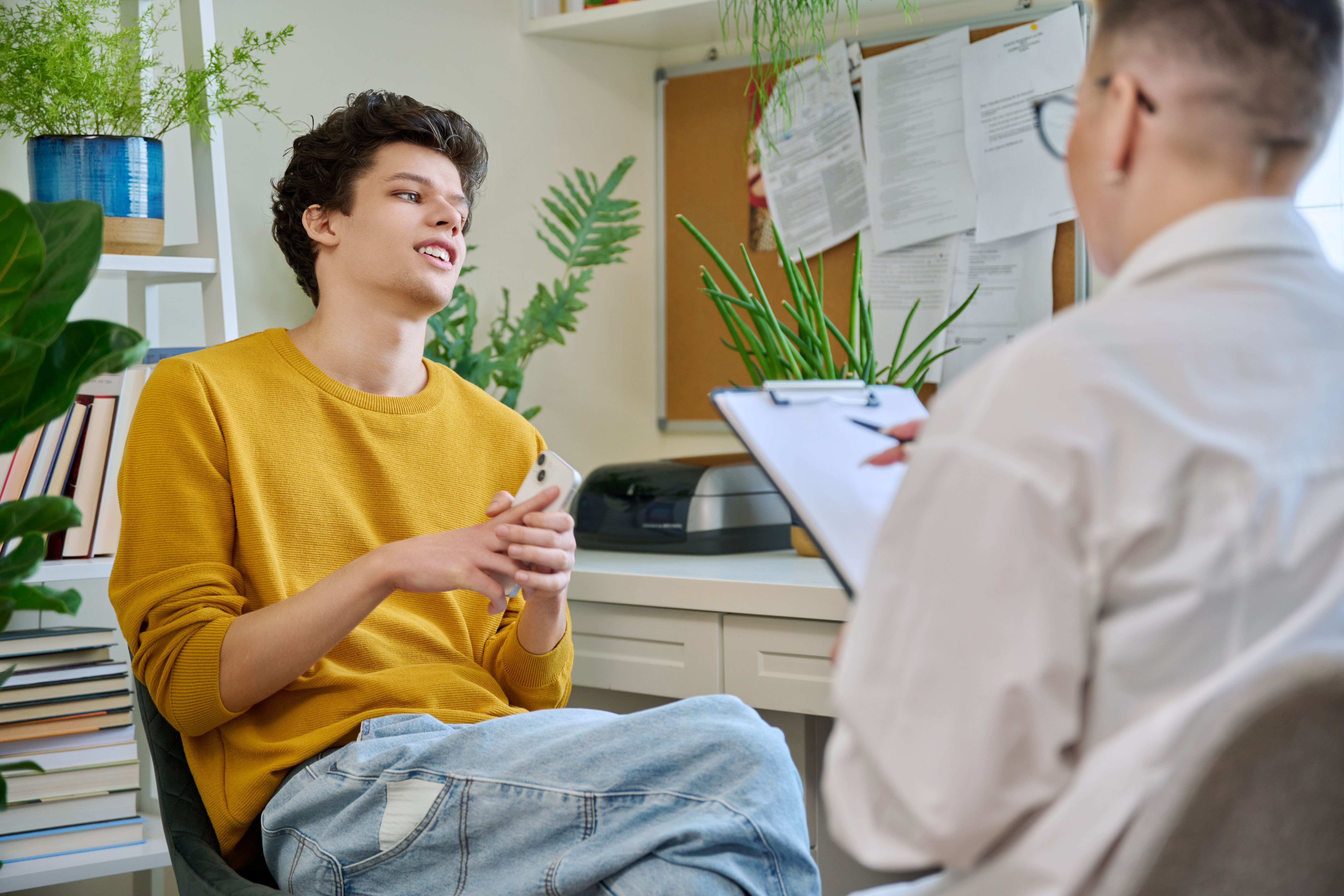 College student guy at meeting with professional counselor, social worker