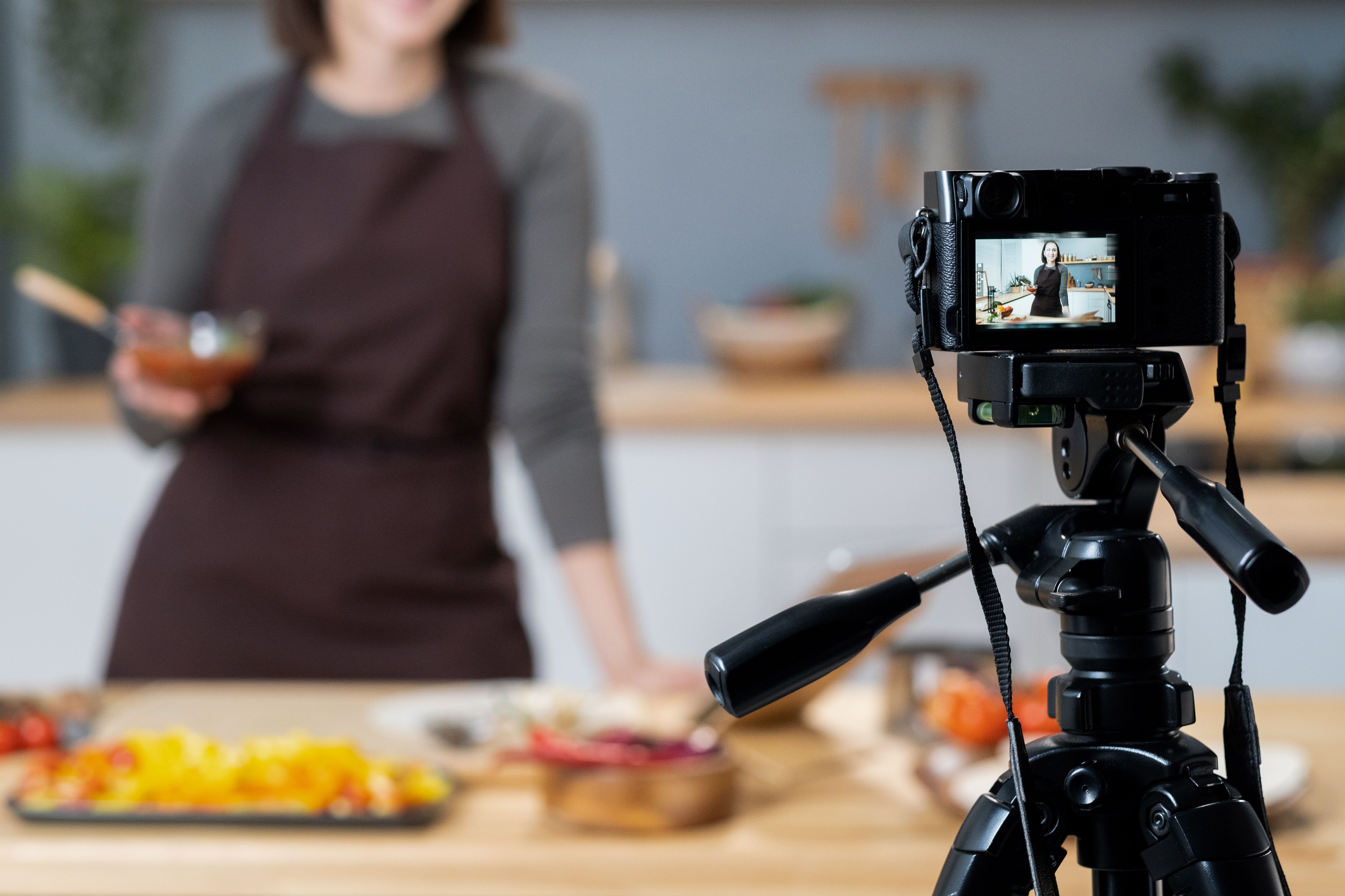 Young female blogger giving cooking masterclass in front of video camera