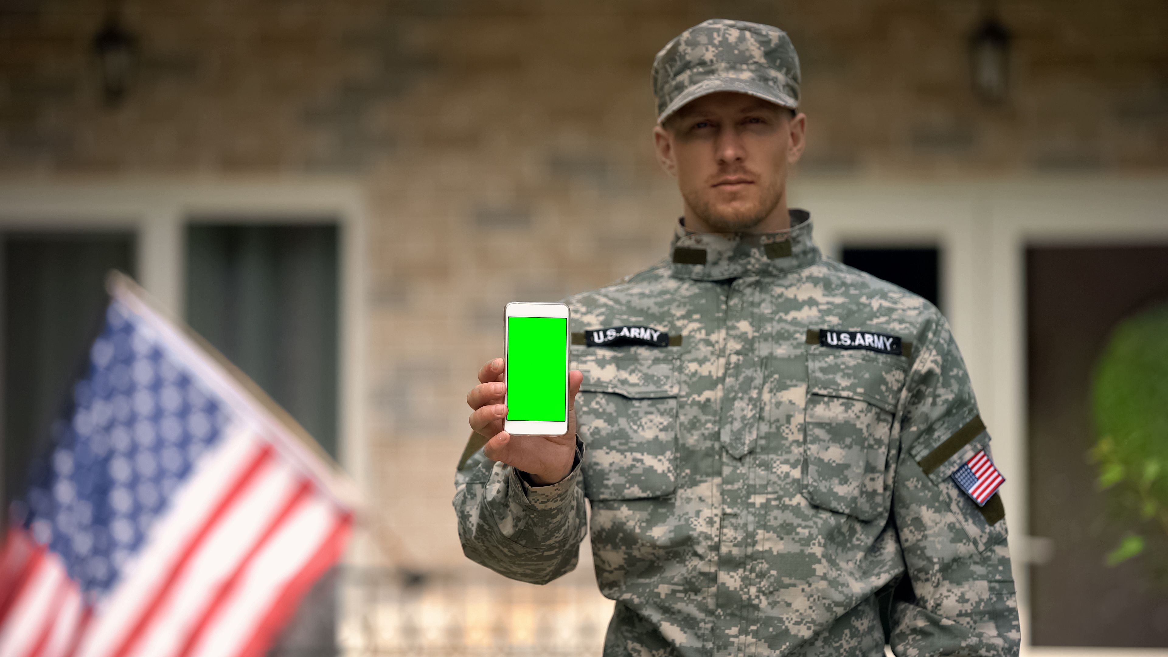 Soldier showing phone with green screen, veterans psychological support online