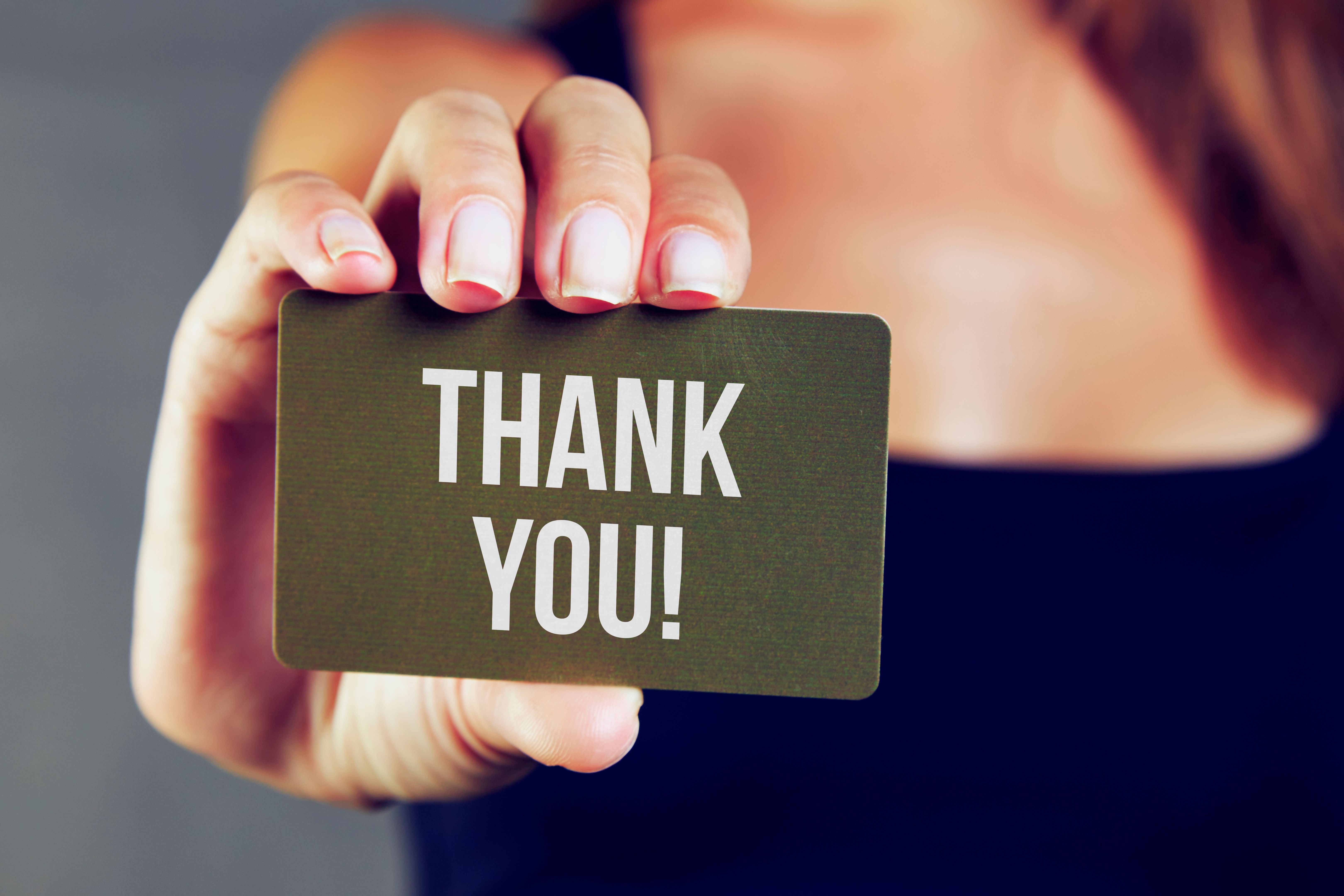 Young woman holding thank you card Young woman holding thank you card