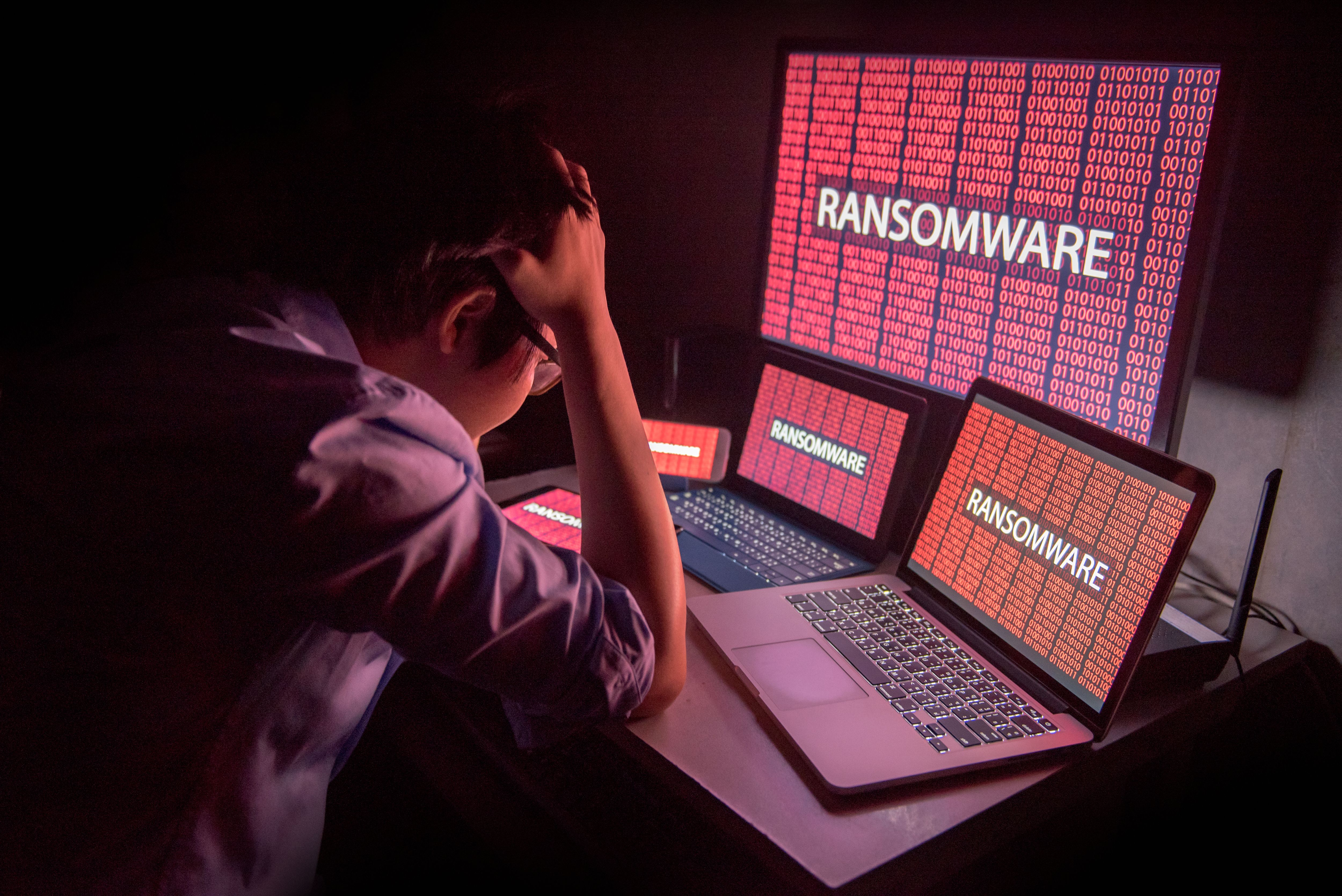 Young Asian male frustrated by ransomware cyber attack