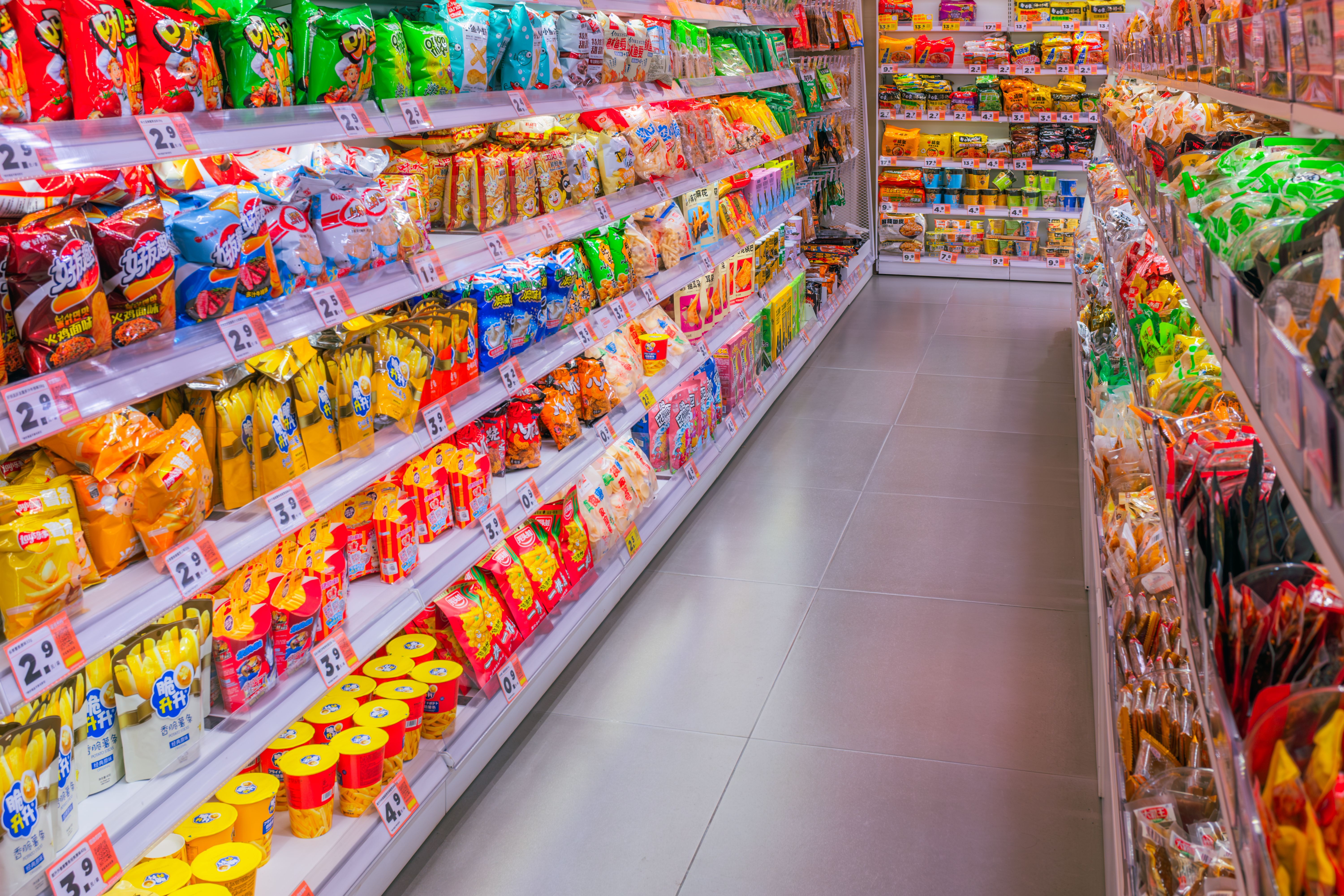 A vibrant and fully stocked snack aisle in a grocery store.