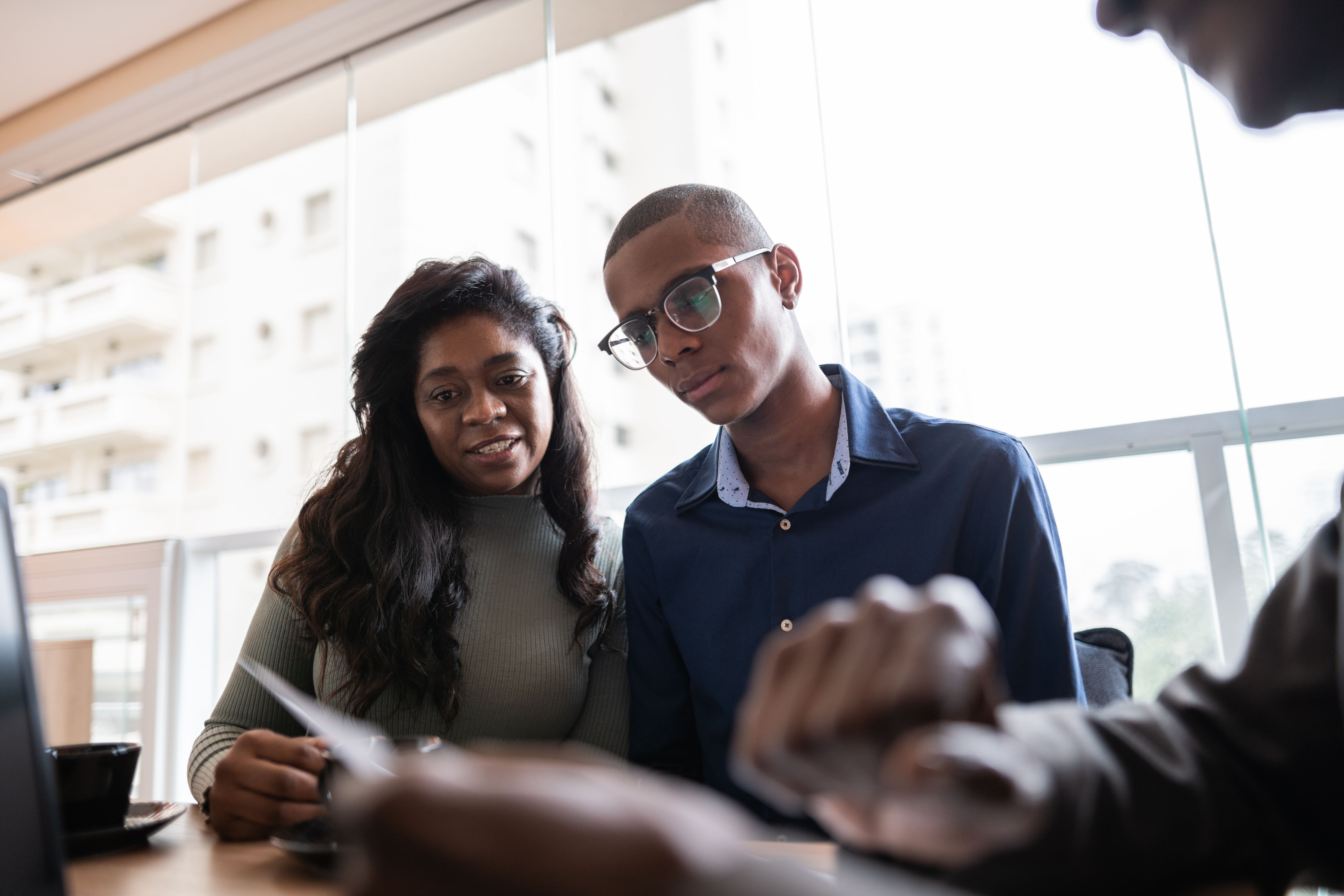 Mother and son in a meeting with a real estate agent or financial advisor at home
