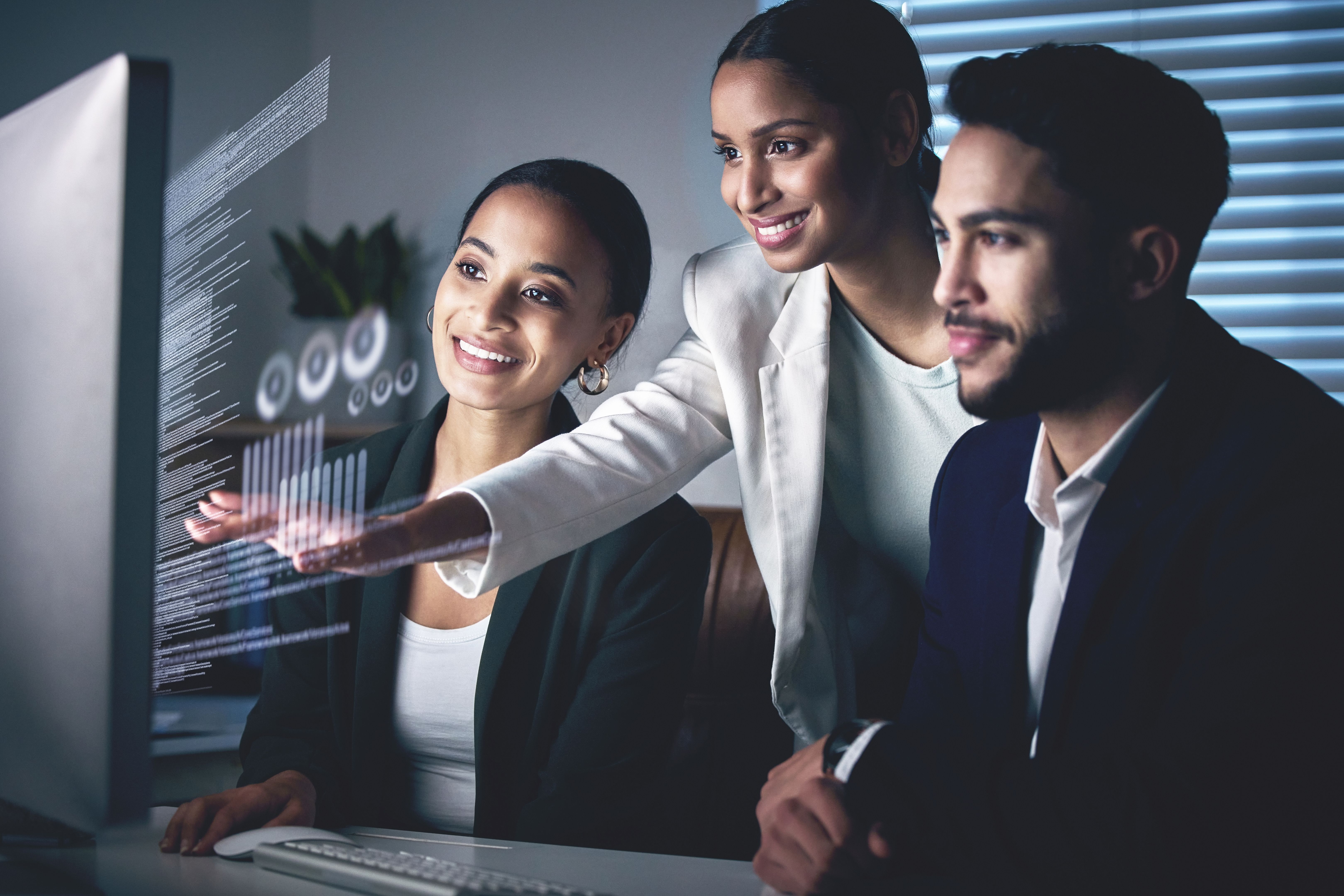 Shot of a young group of businesspeople using a computer while working in the office at night