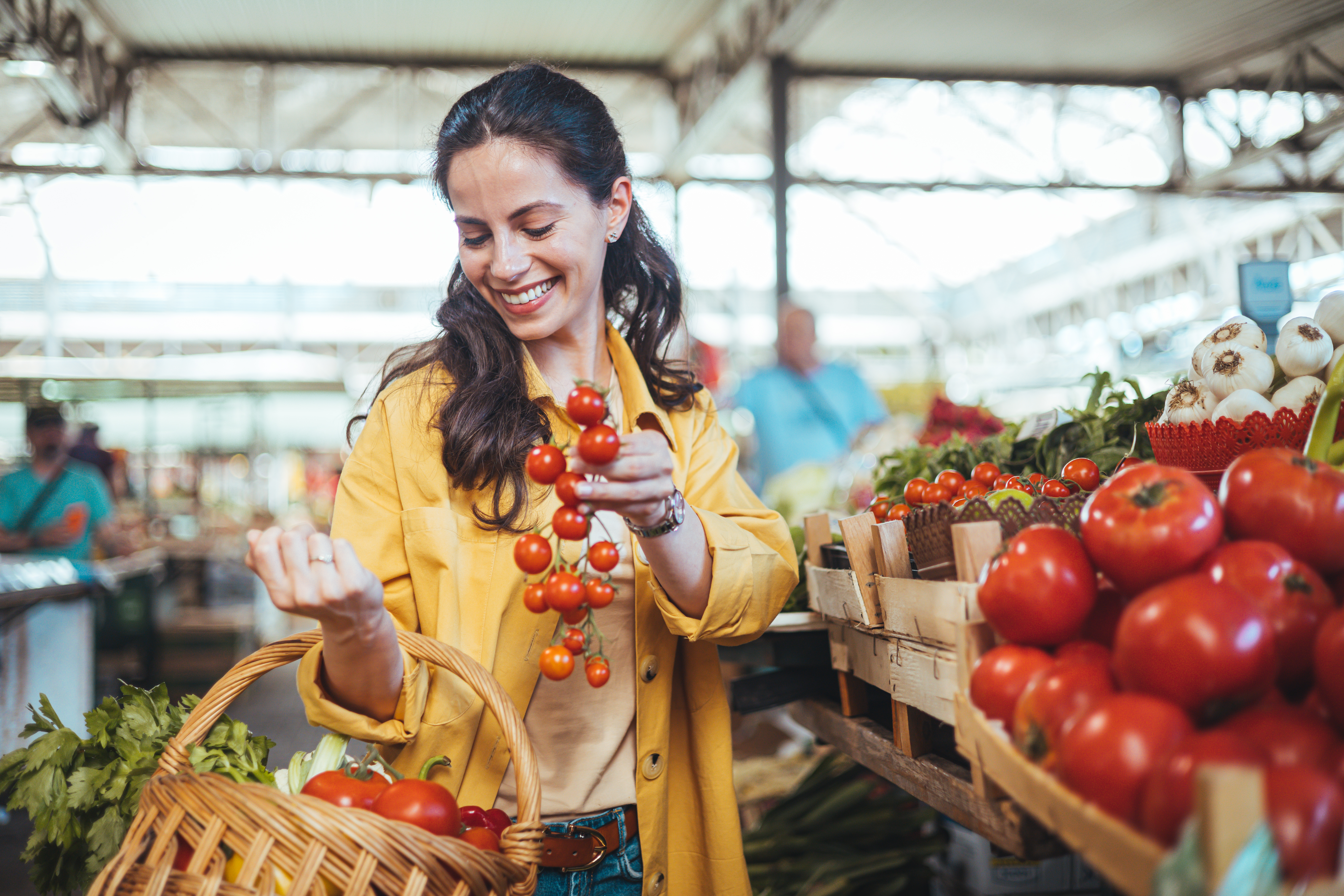 Young woman buying fresh organic produce at a local farmer's market.