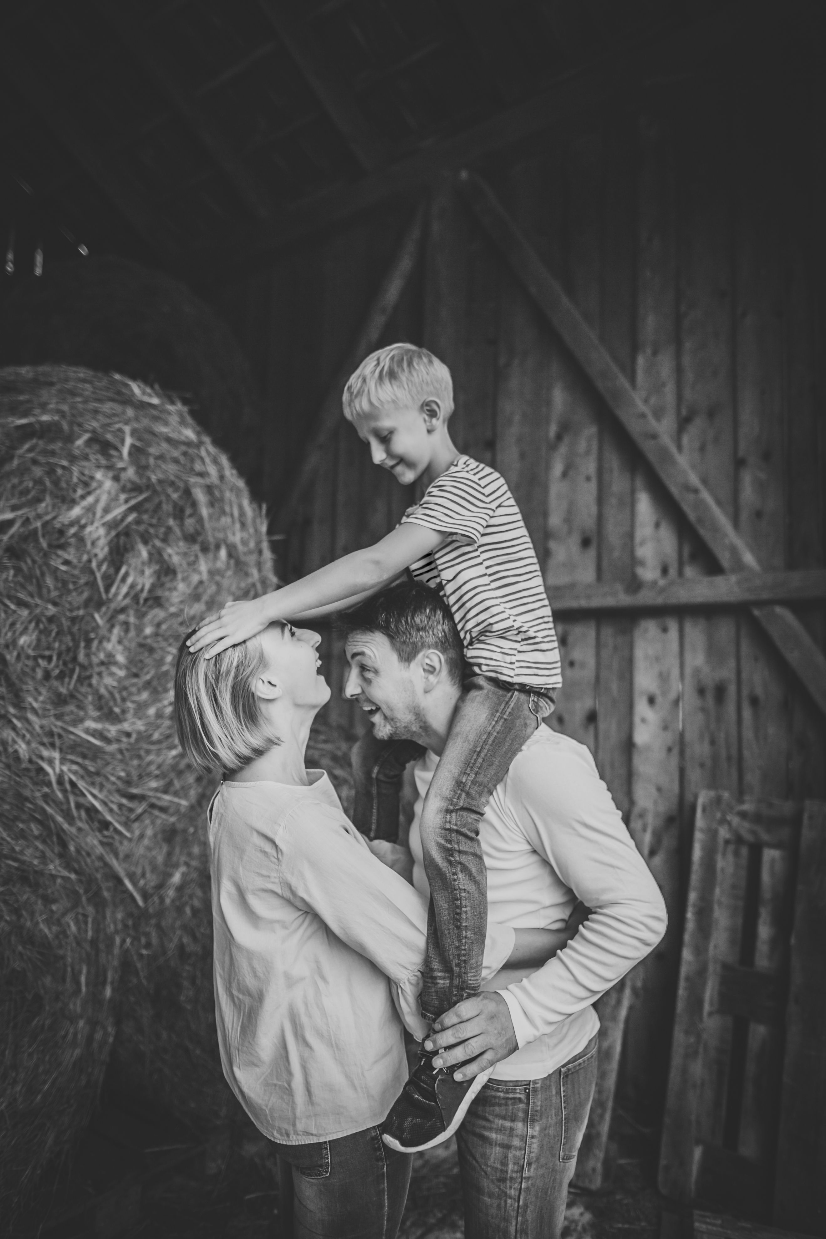 Família feliz com o filho no celeiro