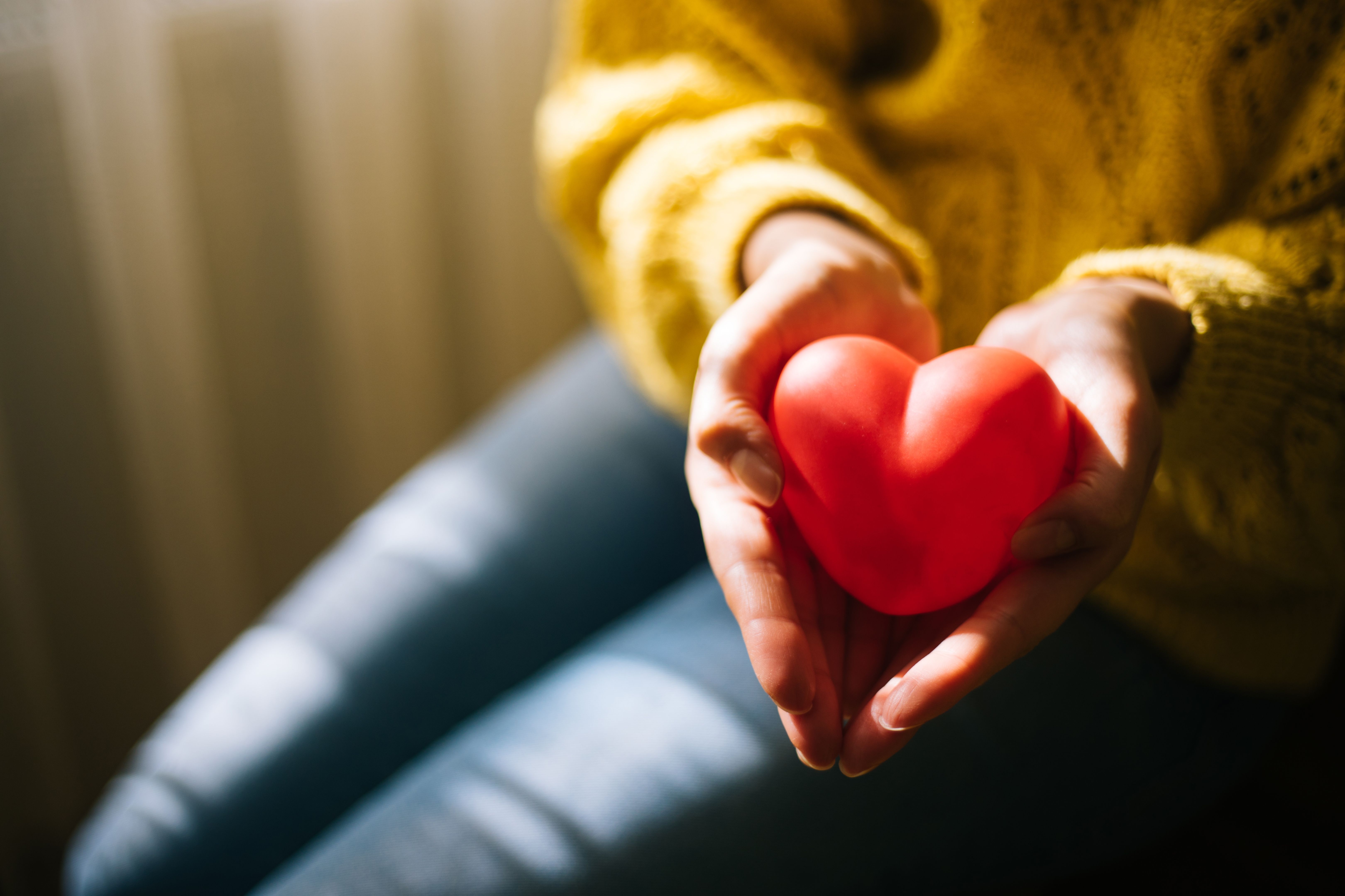 Mujer sosteniendo el corazón rojo