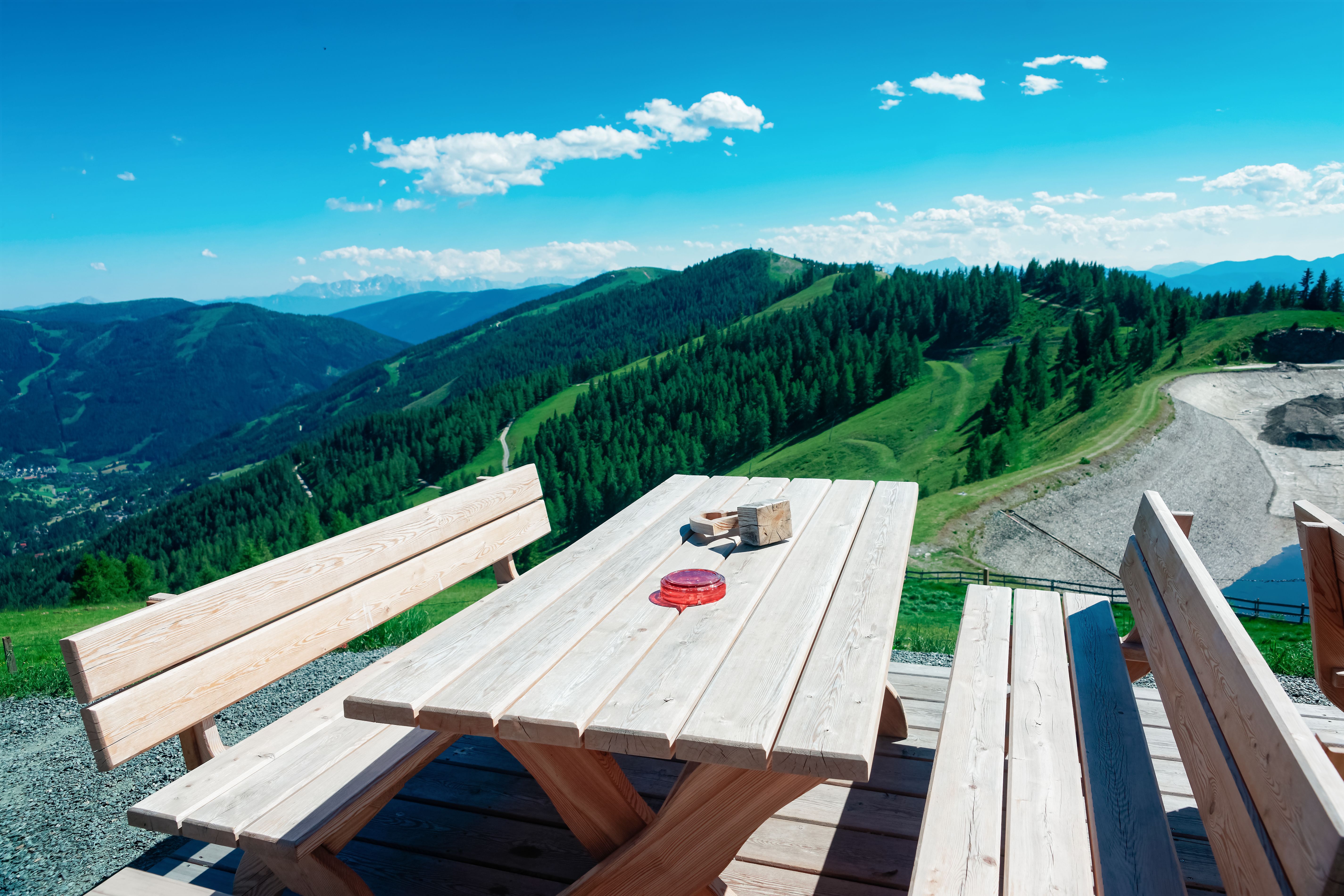 Open air cafe with wooden tables and chairs in Alps mountains in Bad Kleinkirchheim of Austria