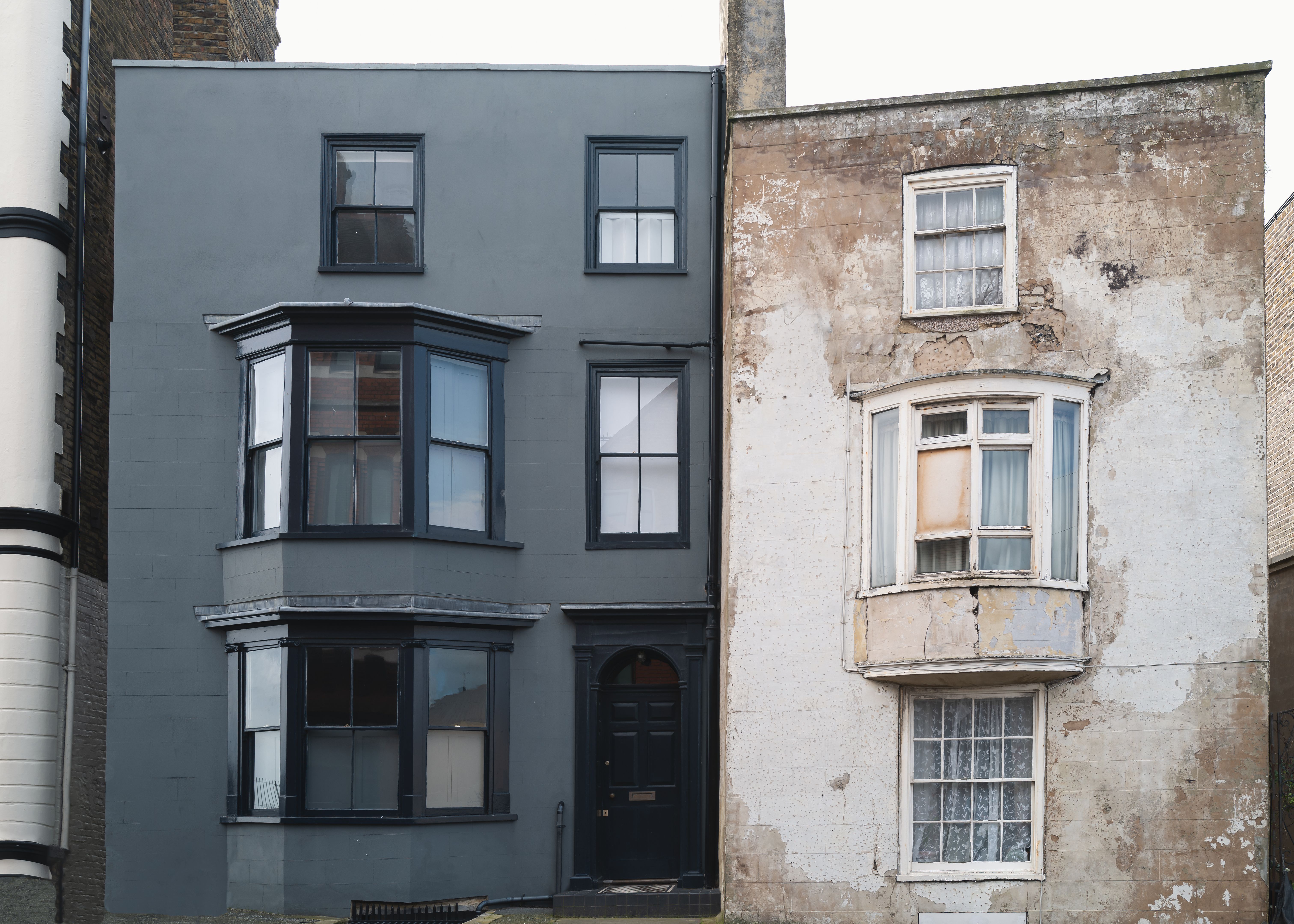 A renovated three floor town house alongside a similar building before restoration. A renovated three floor town house alongside a similar building before restoration.
