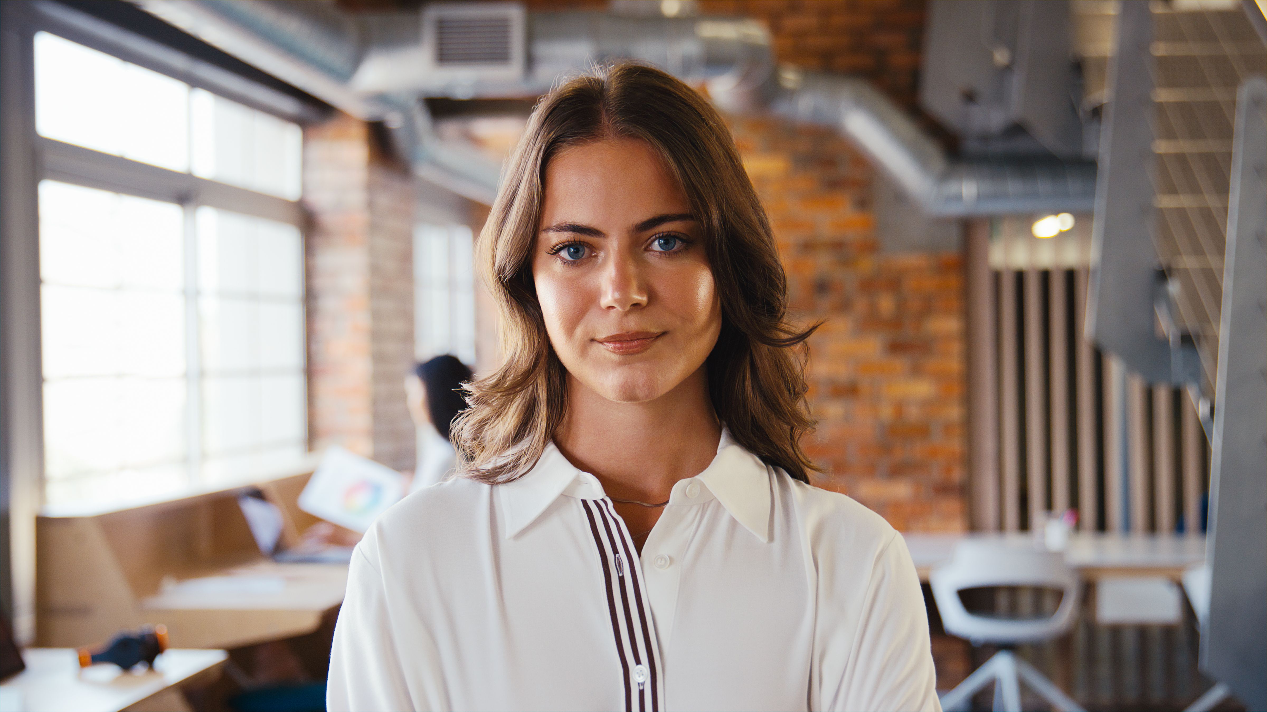 Portrait Of Serious Young Businesswoman Working In Modern Open Plan Office